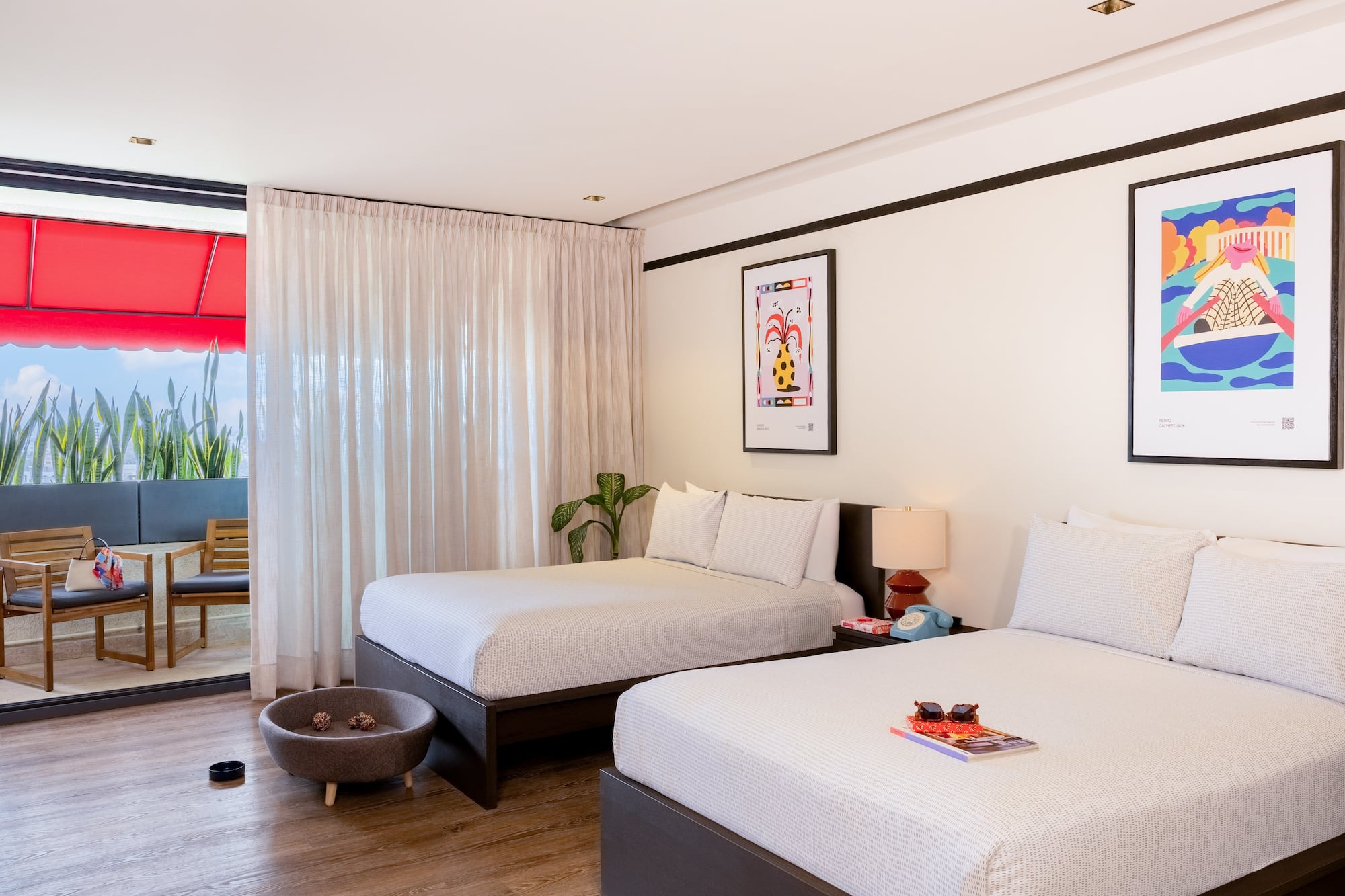 Pet-friendly hotel room with two beds, modern decor, artwork, and balcony.