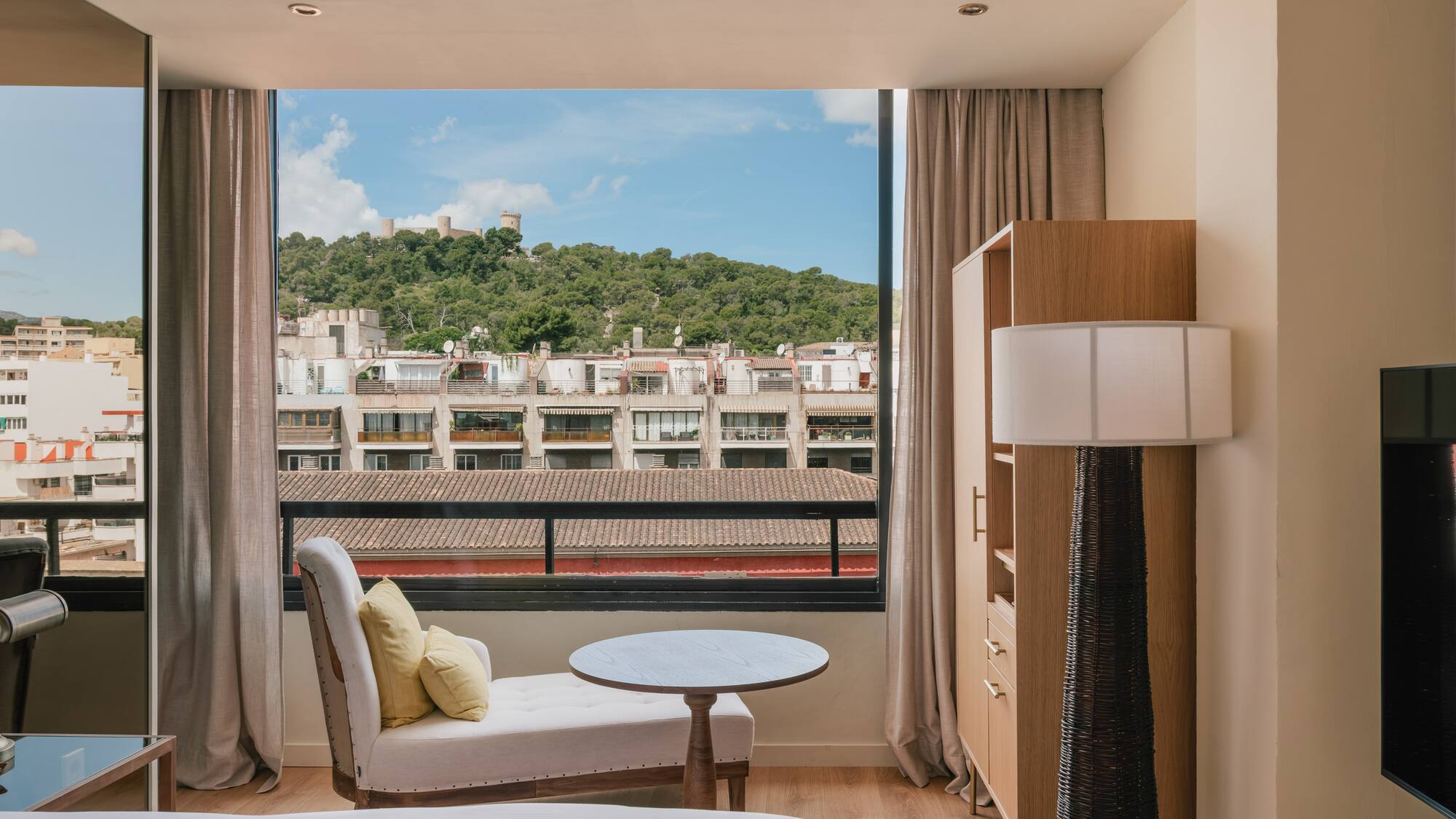 a room with a bed and a table and a window