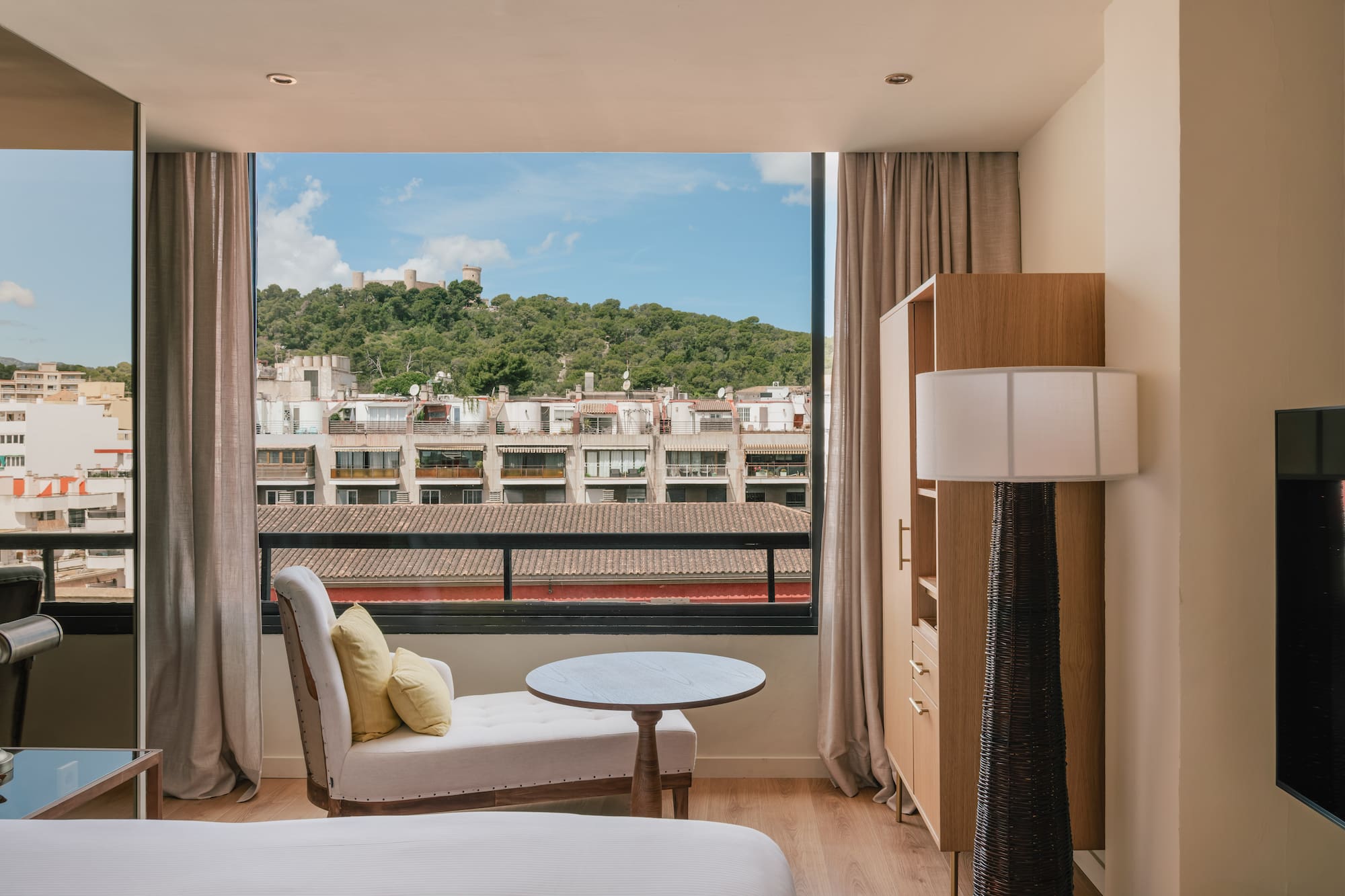 a room with a bed and a table and a window