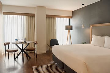 a room with a bed and a table and chairs