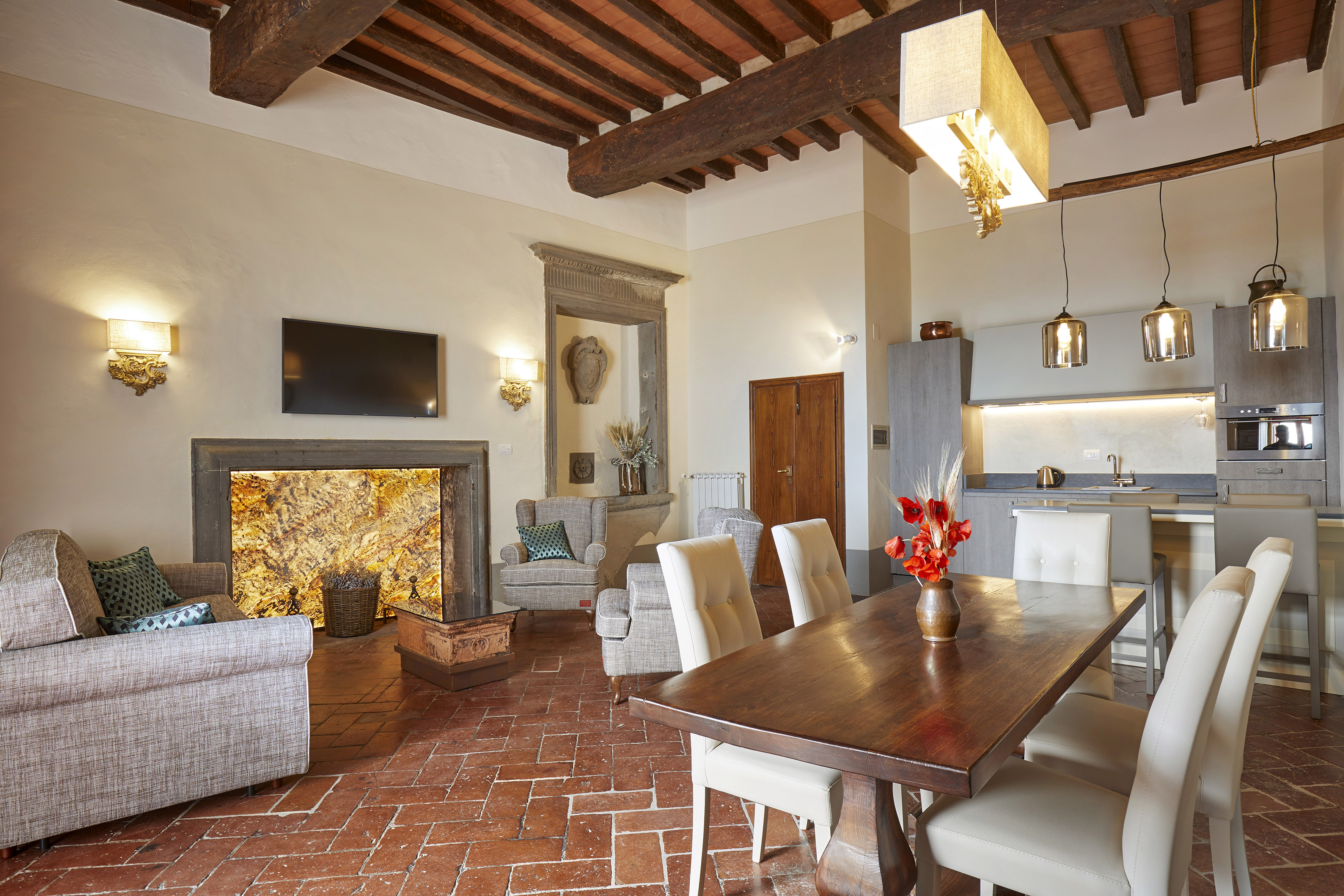 Tuscan living dining kitchen. Exposed beams, terracotta floor, fireplace.