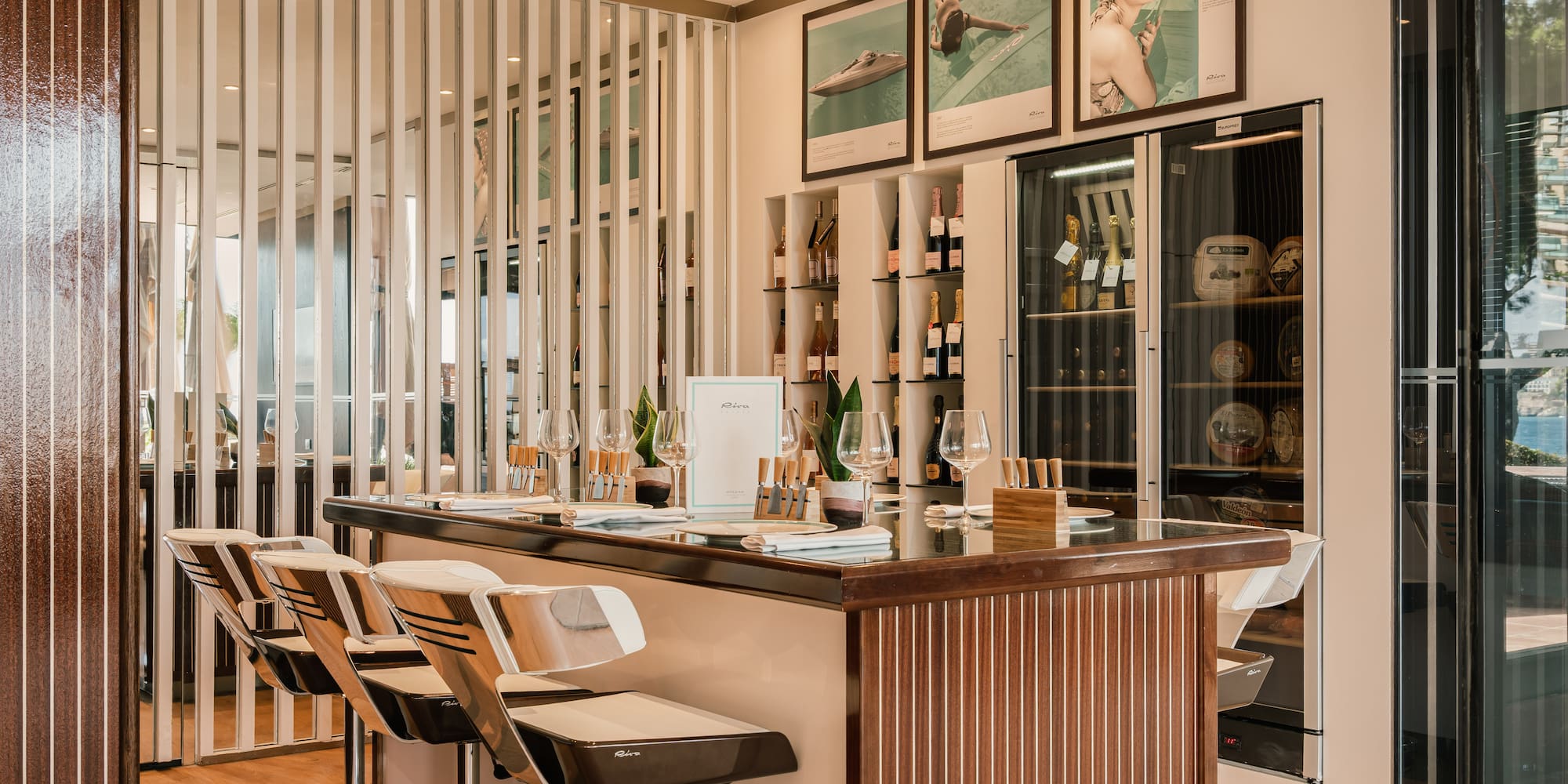 a bar with chairs and a shelf with wine bottles