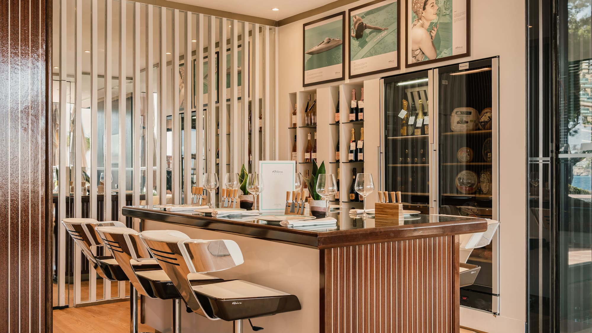 a bar with chairs and a shelf with wine bottles
