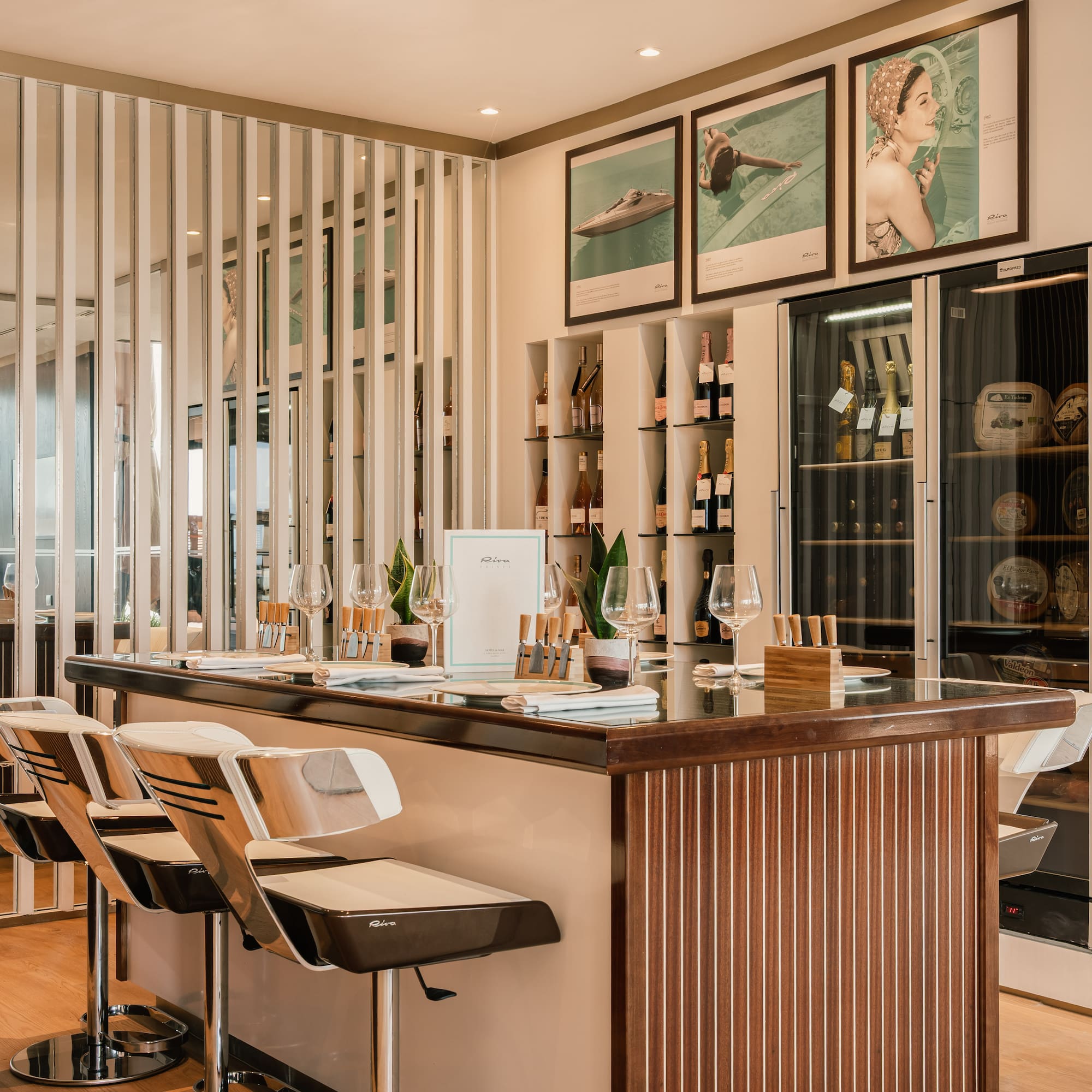 a bar with chairs and a shelf with wine bottles