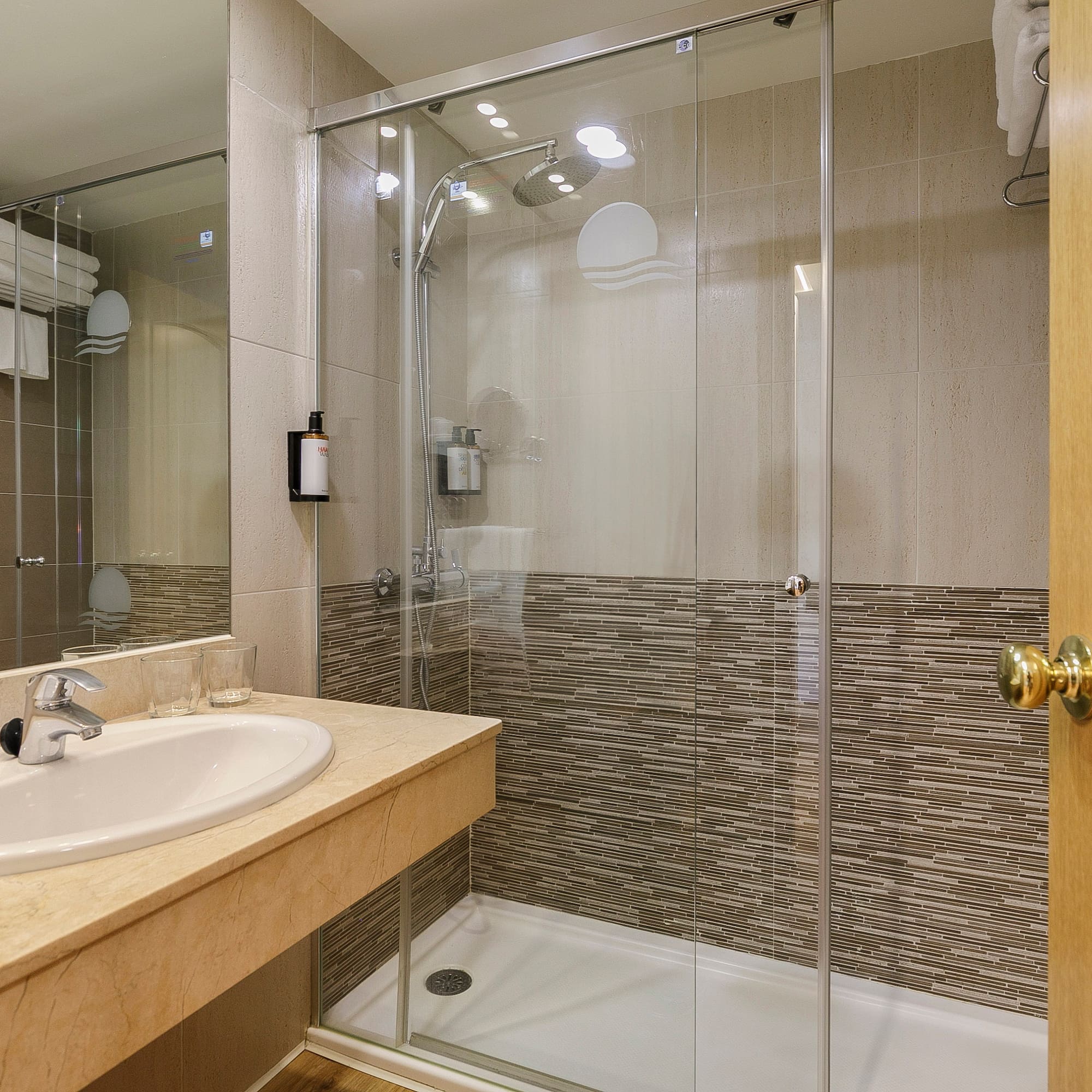 a bathroom with a glass shower and sink