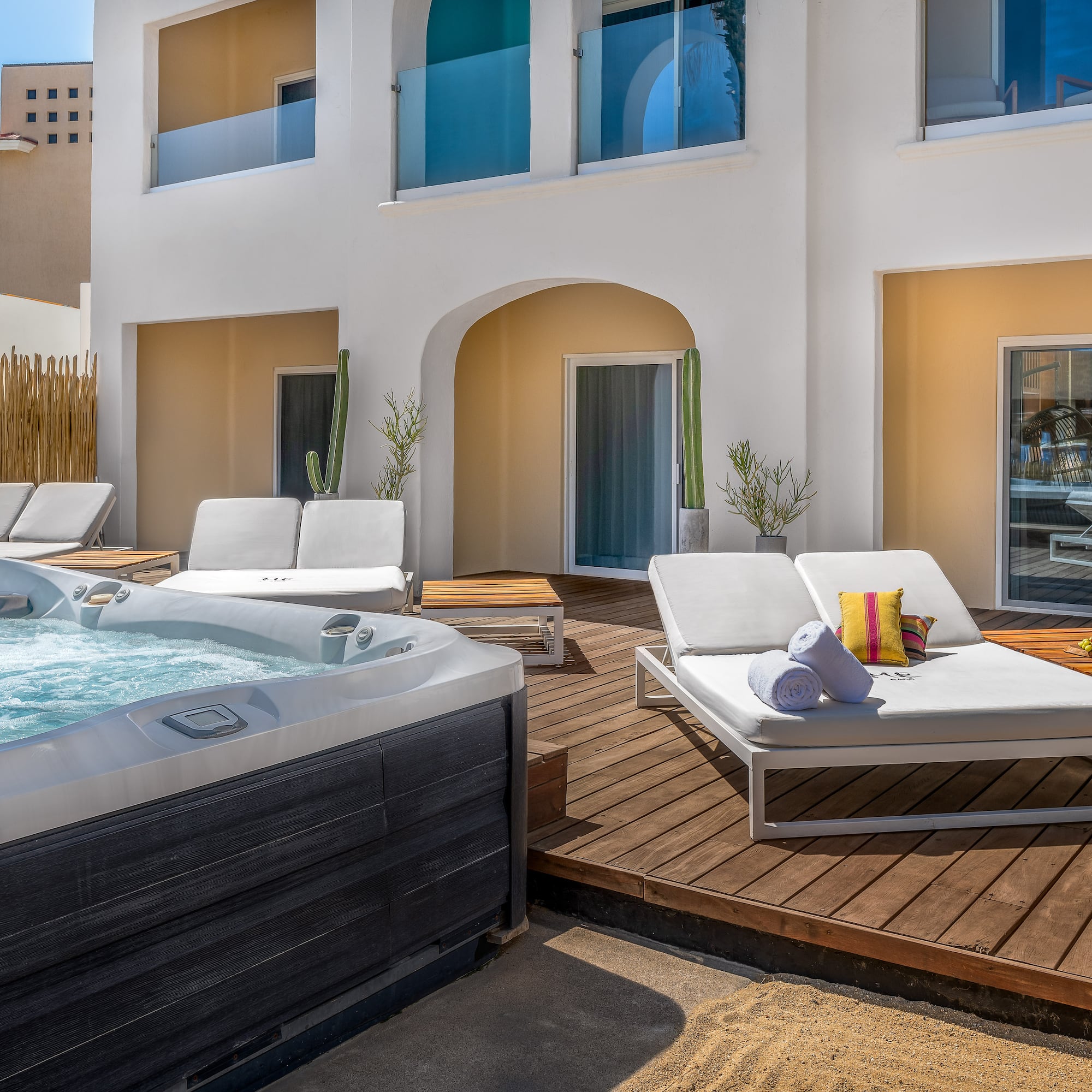a hot tub and lounge chairs on a deck