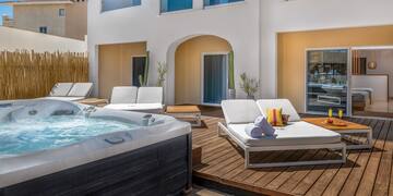 a hot tub and lounge chairs on a deck