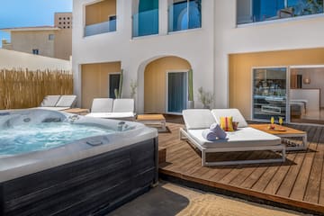 a hot tub and lounge chairs on a deck