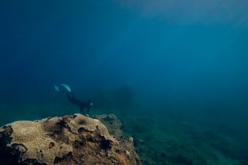 a person in a scuba gear swimming under water
