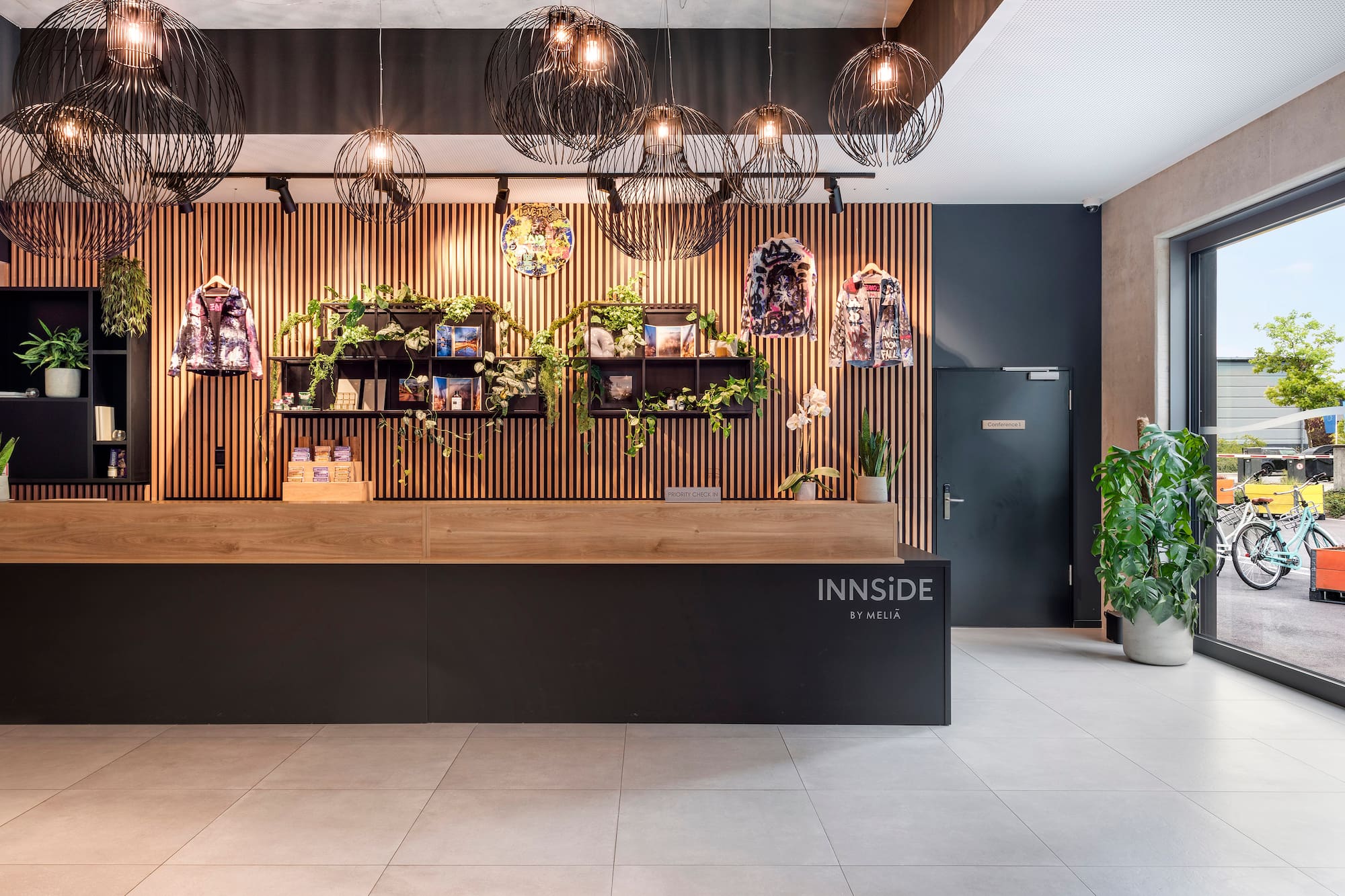 INNSiDE by Meliá hotel reception: modern design, plants, stylish pendant lights.