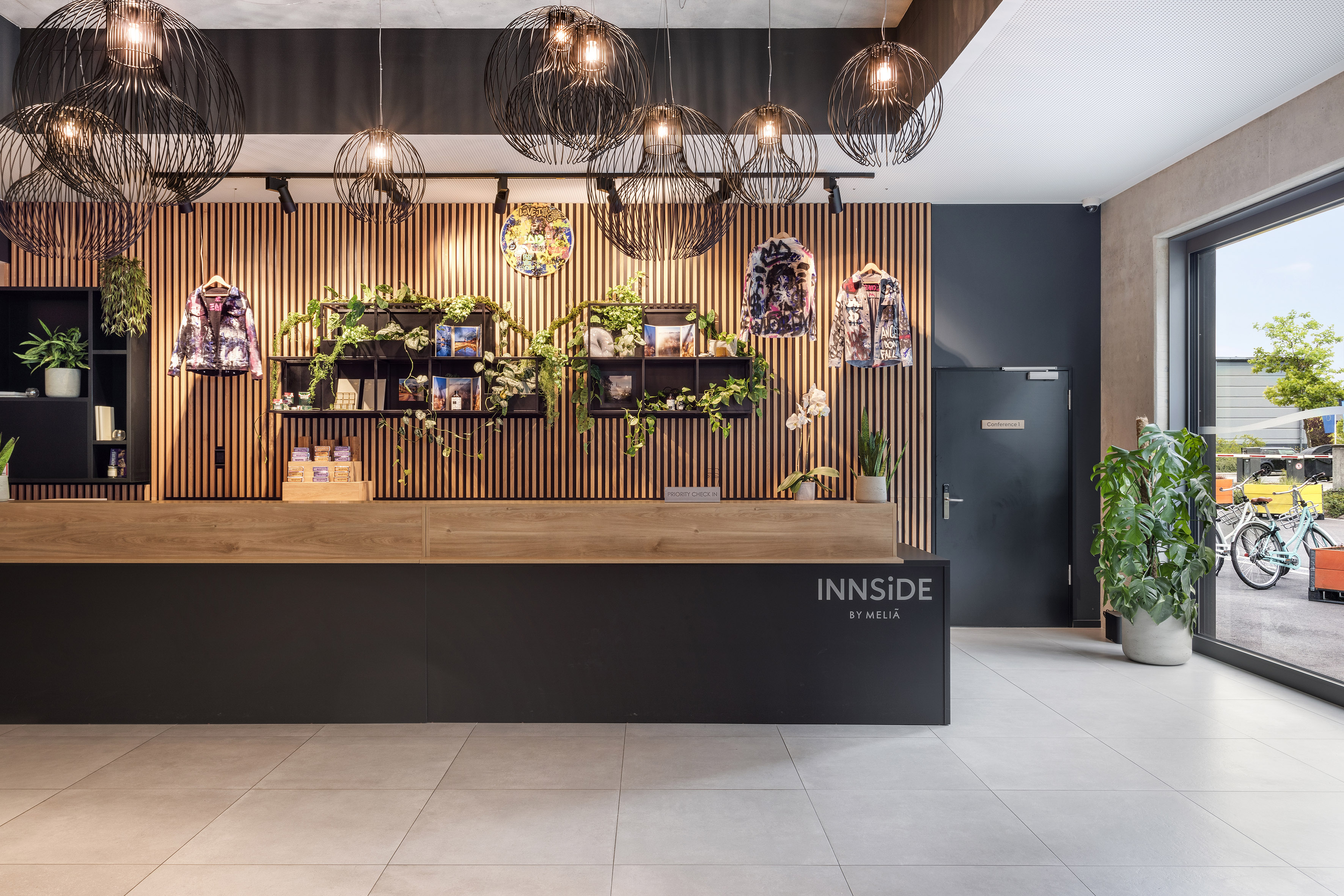 INNSiDE by Meliá hotel reception: modern design, plants, stylish pendant lights.