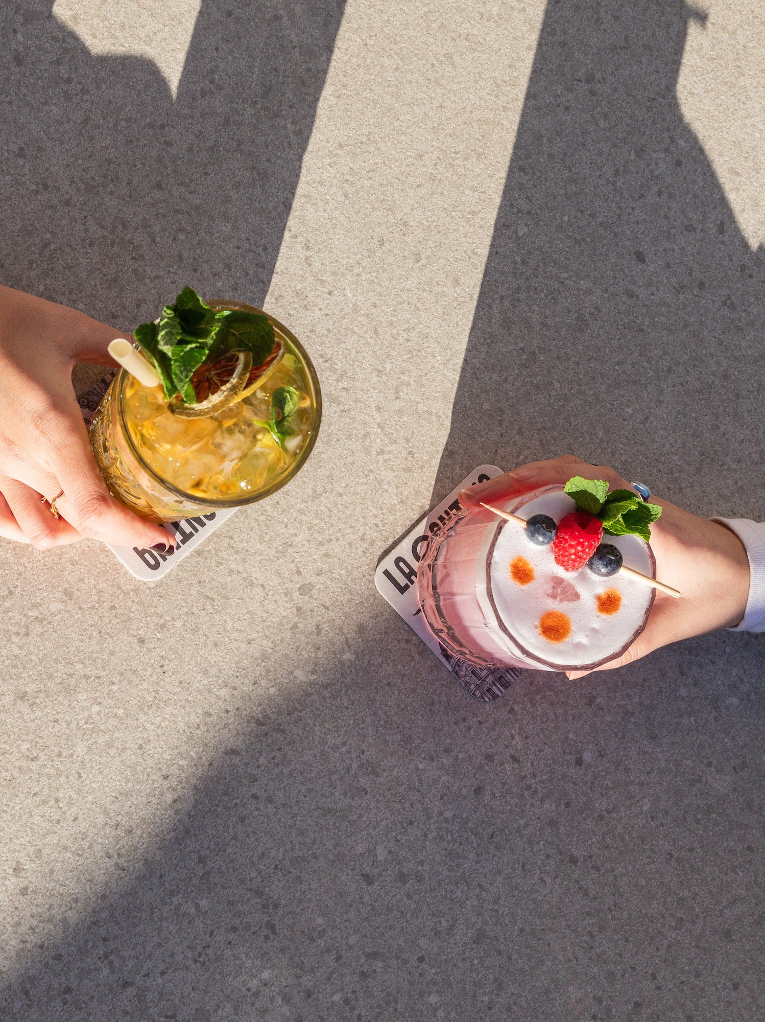 two hands holding drinks