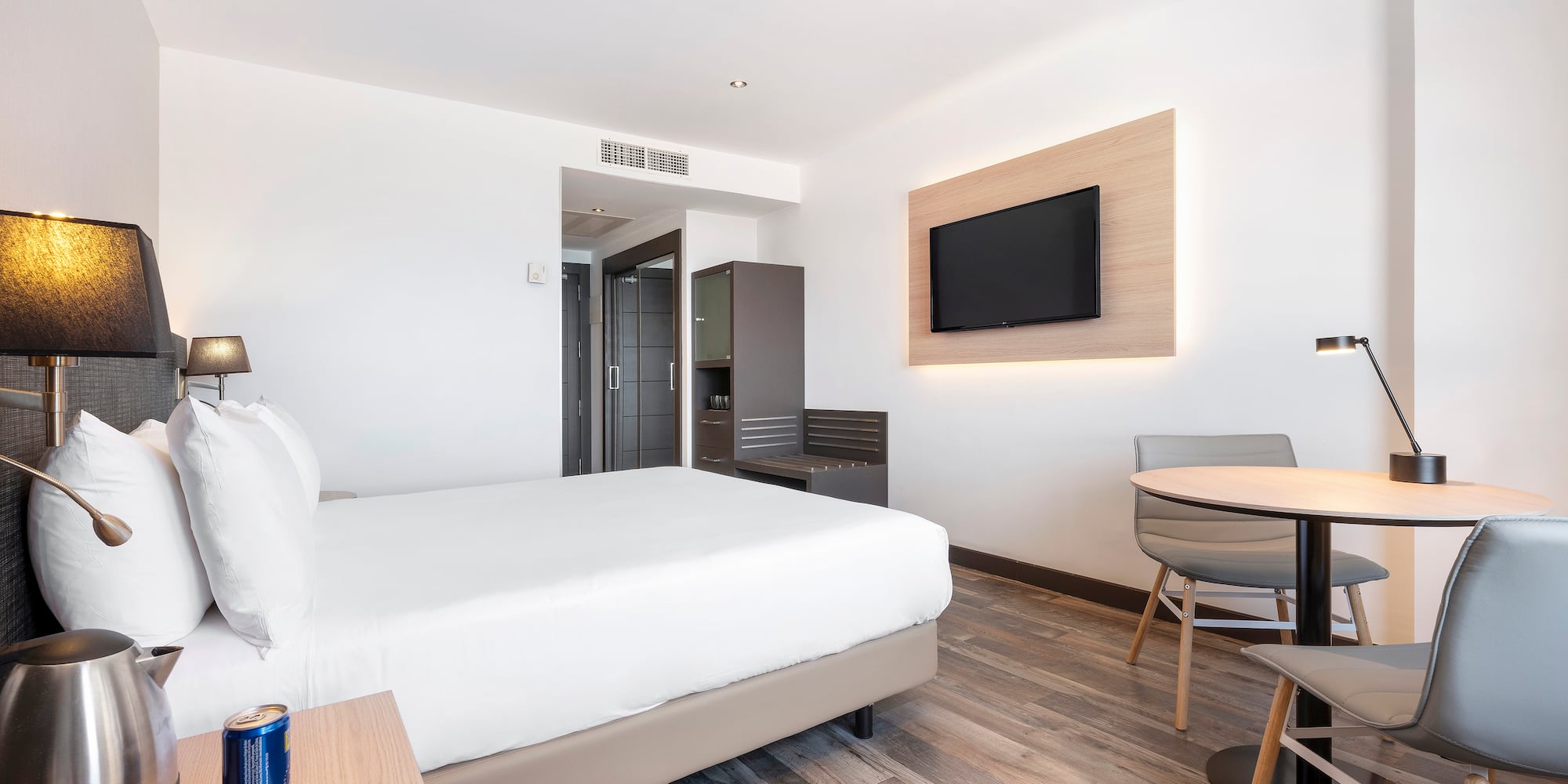 a room with a bed and a table and a television