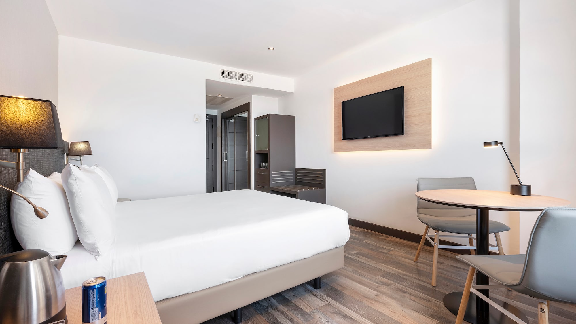 a room with a bed and a table and a television