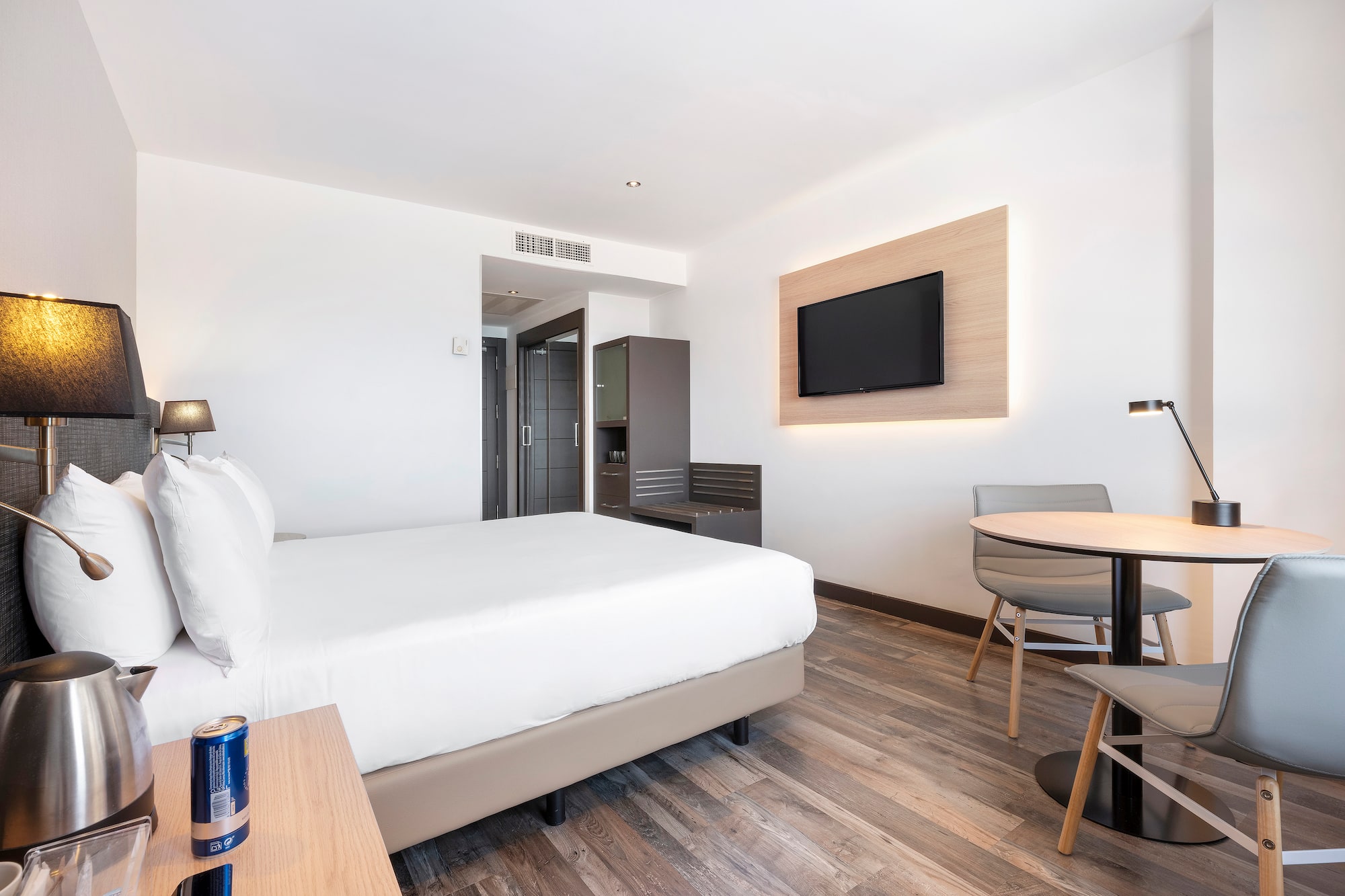 a room with a bed and a table and a television