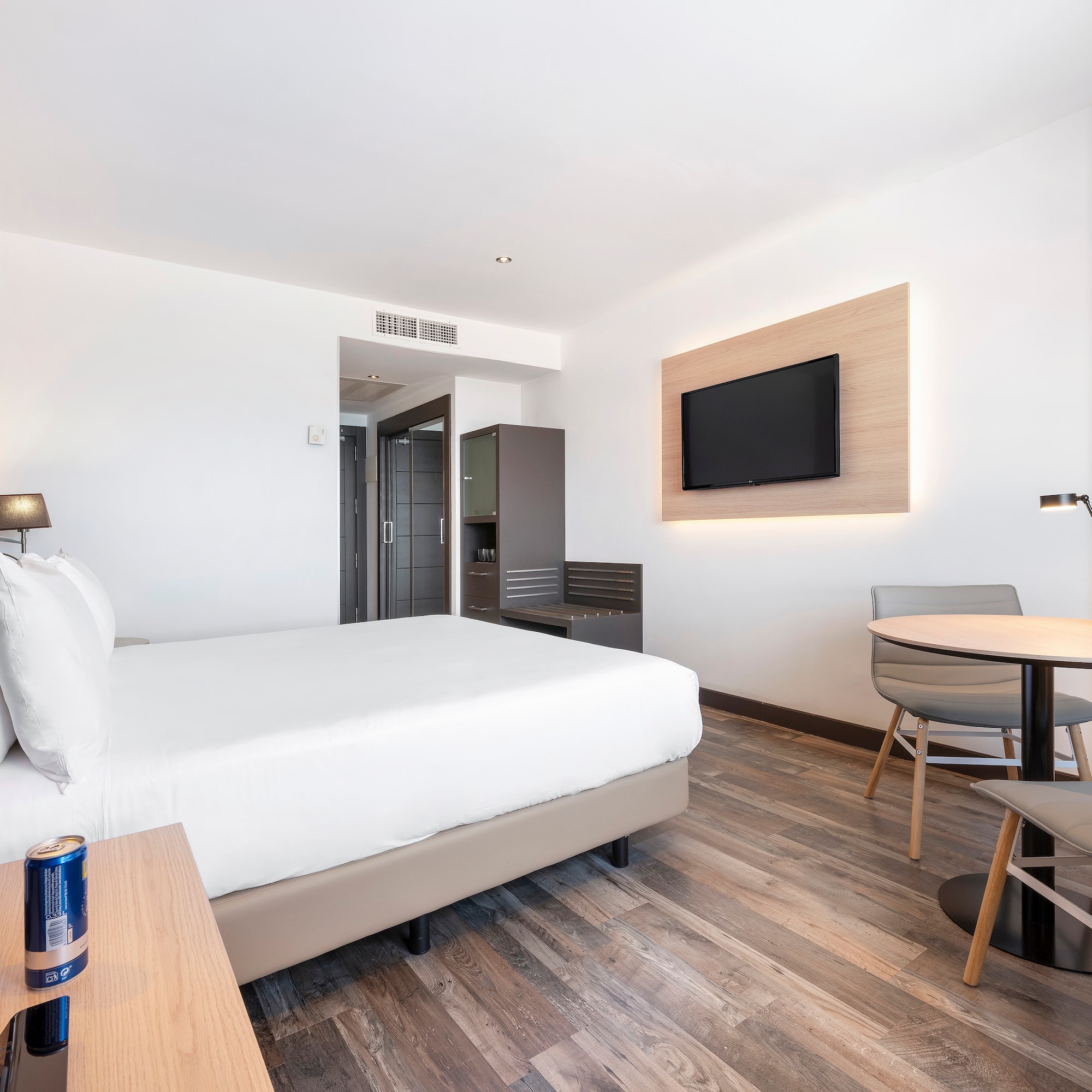 a room with a bed and a table and a television