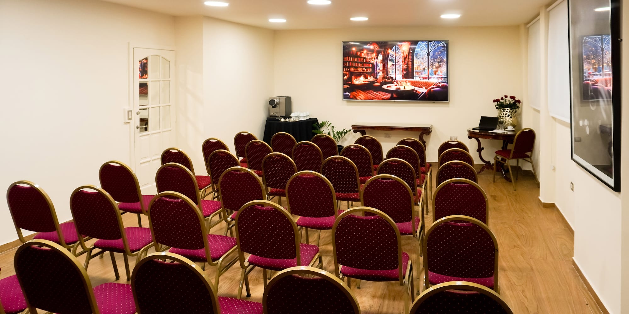 a room with red chairs and a screen