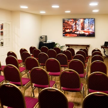 a room with red chairs and a screen