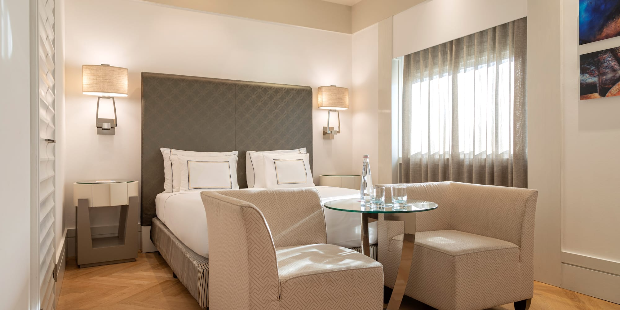 a room with a bed and chairs