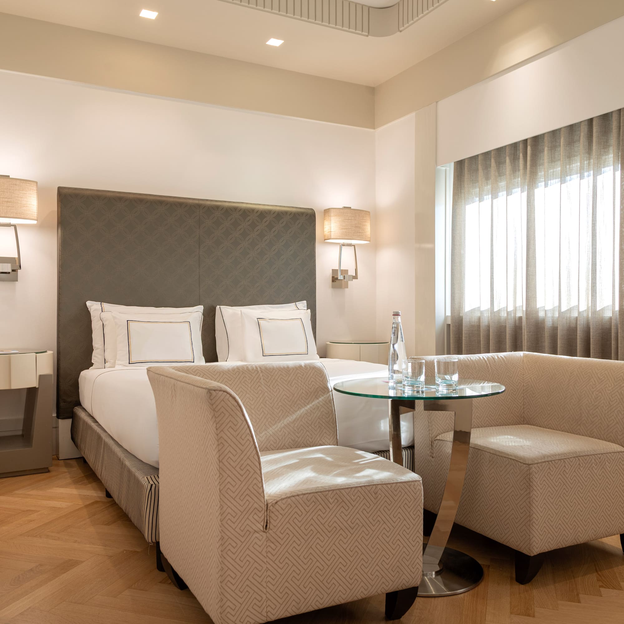 a room with a bed and chairs