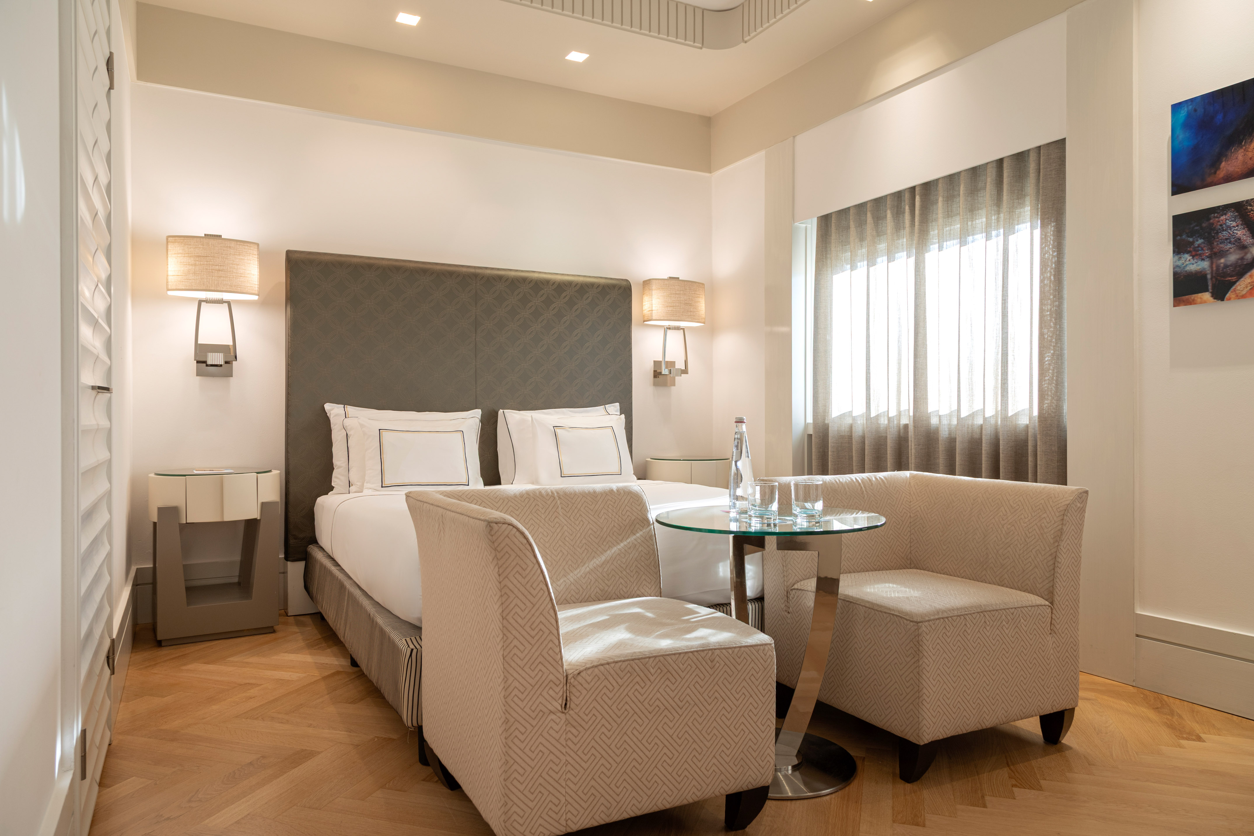 a room with a bed and chairs