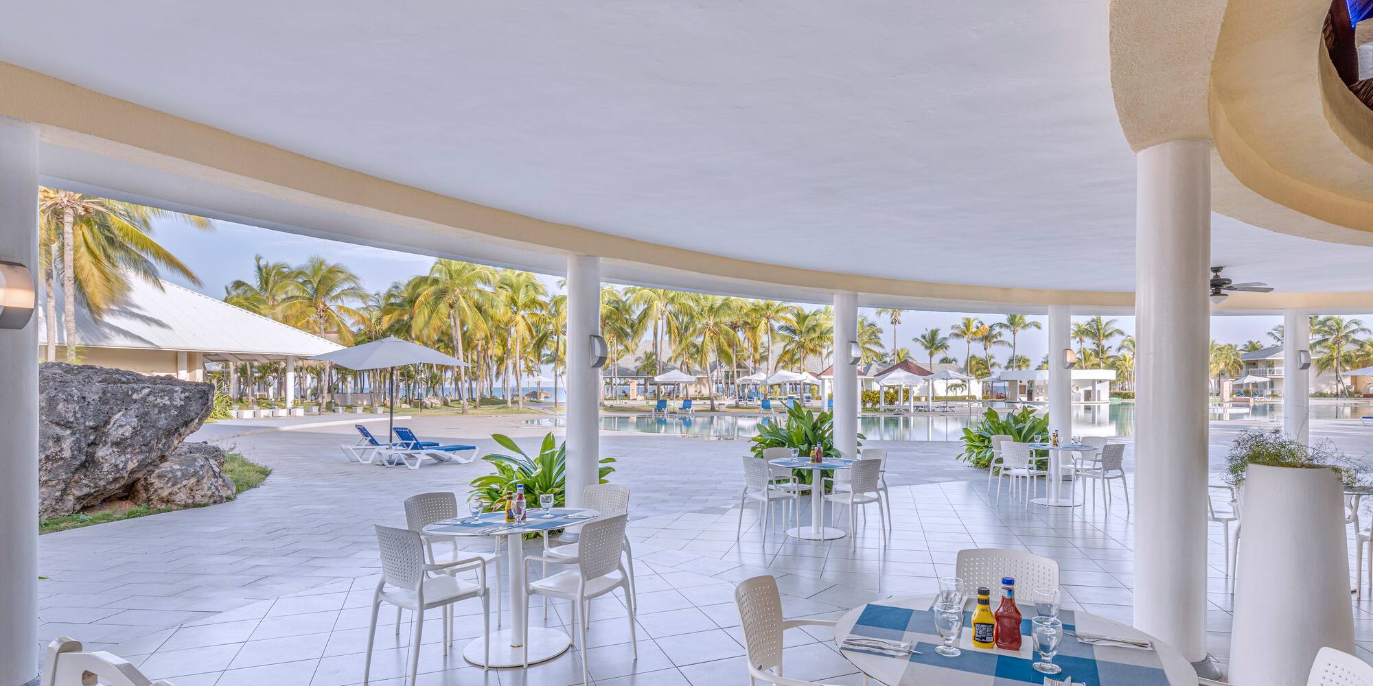 a patio with tables and chairs and umbrellas