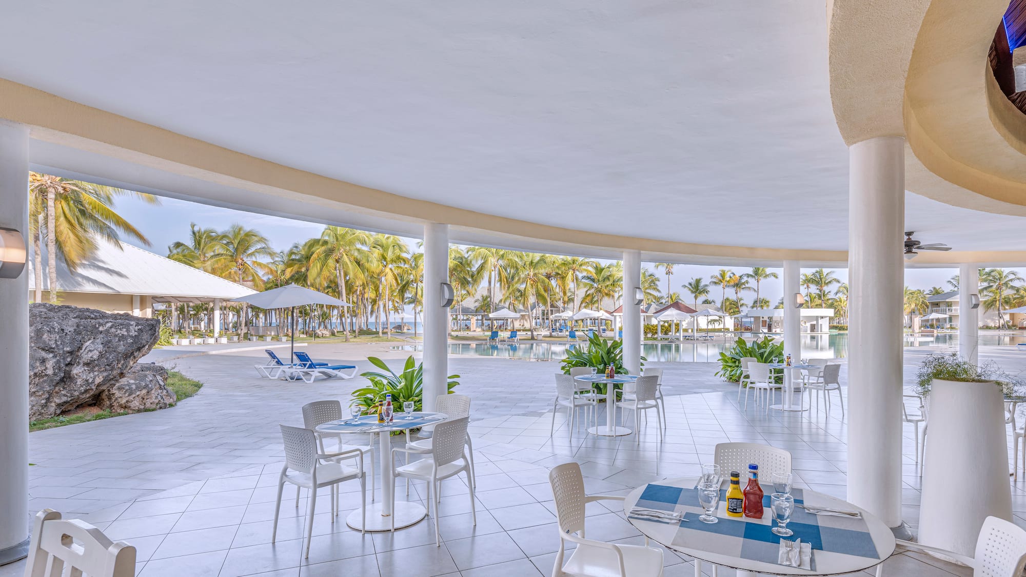 a patio with tables and chairs and umbrellas