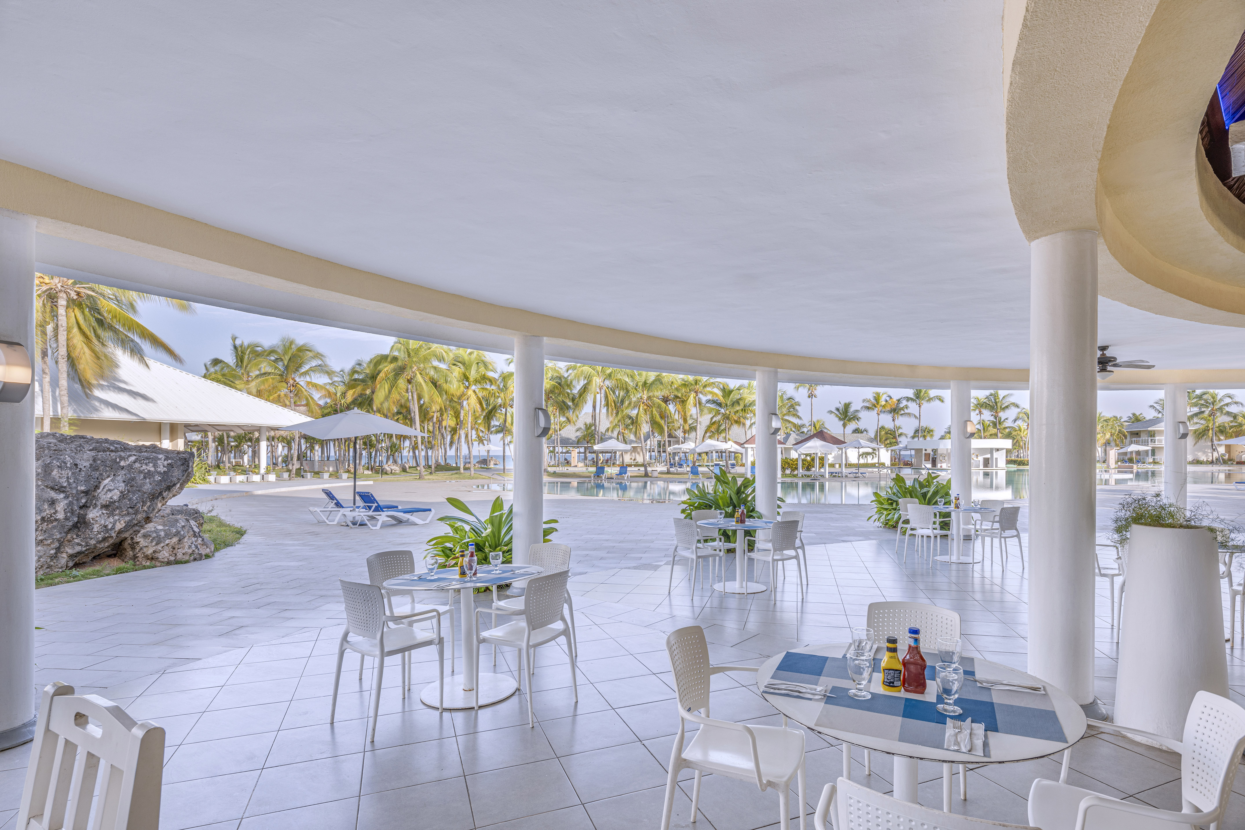 a patio with tables and chairs and umbrellas