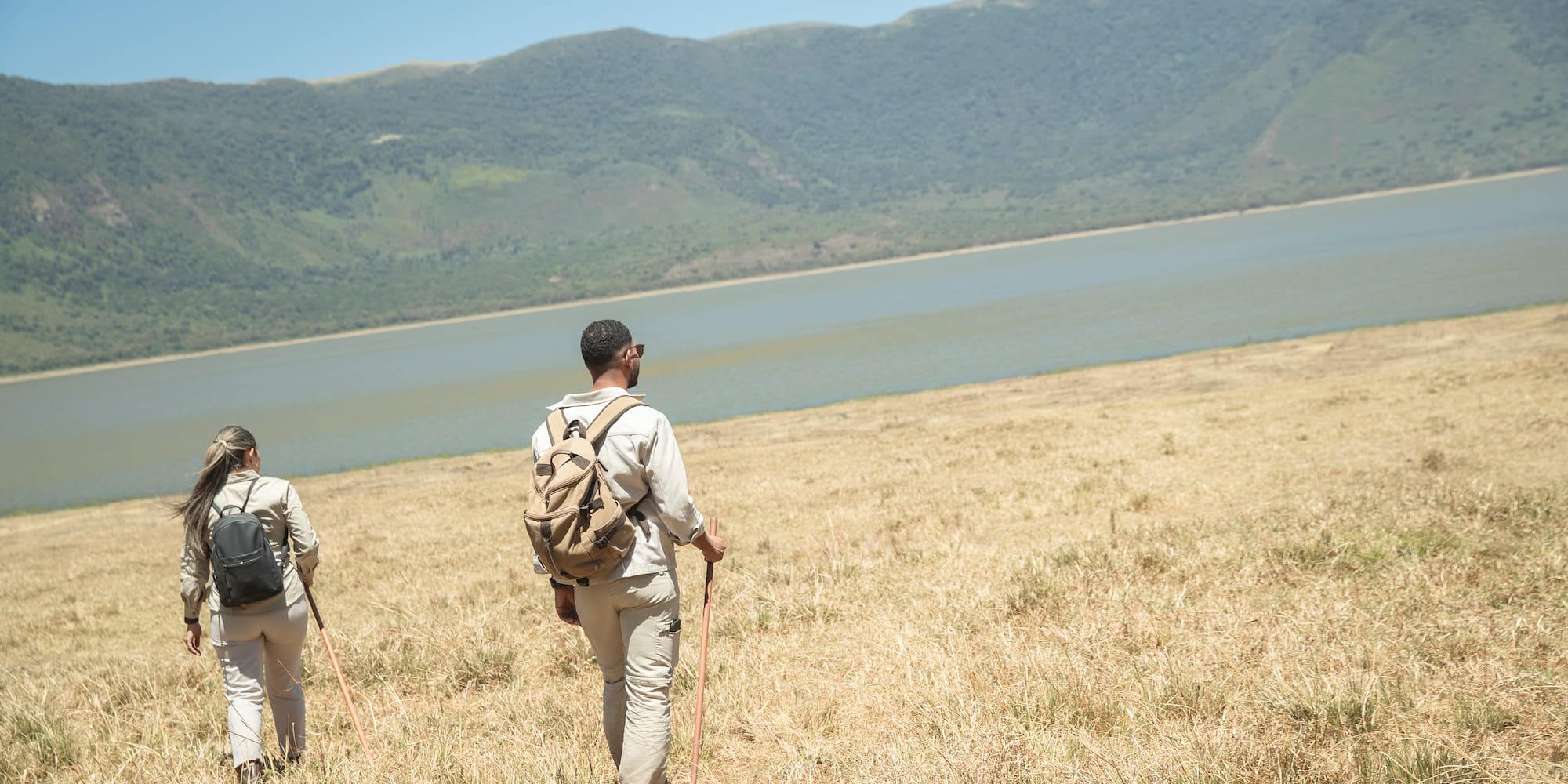 a couple of people hiking in a field