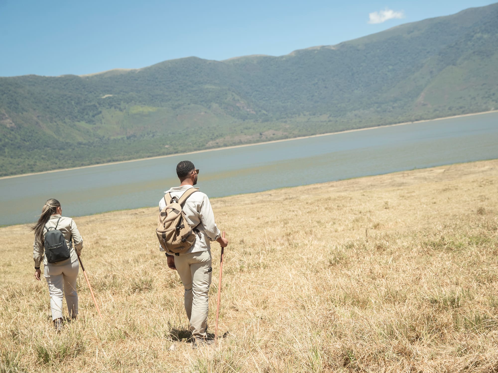 a couple of people hiking in a field