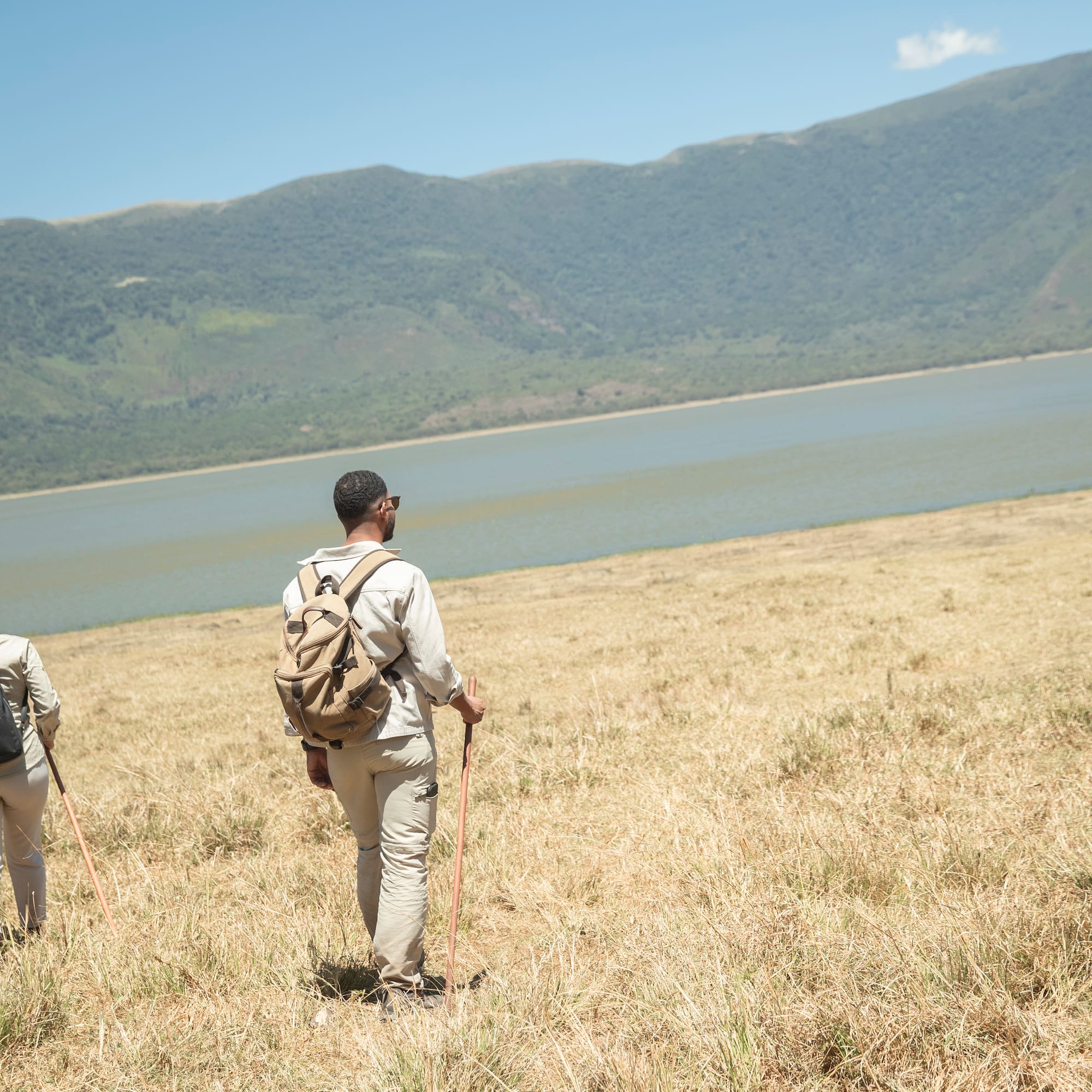 a couple of people hiking in a field