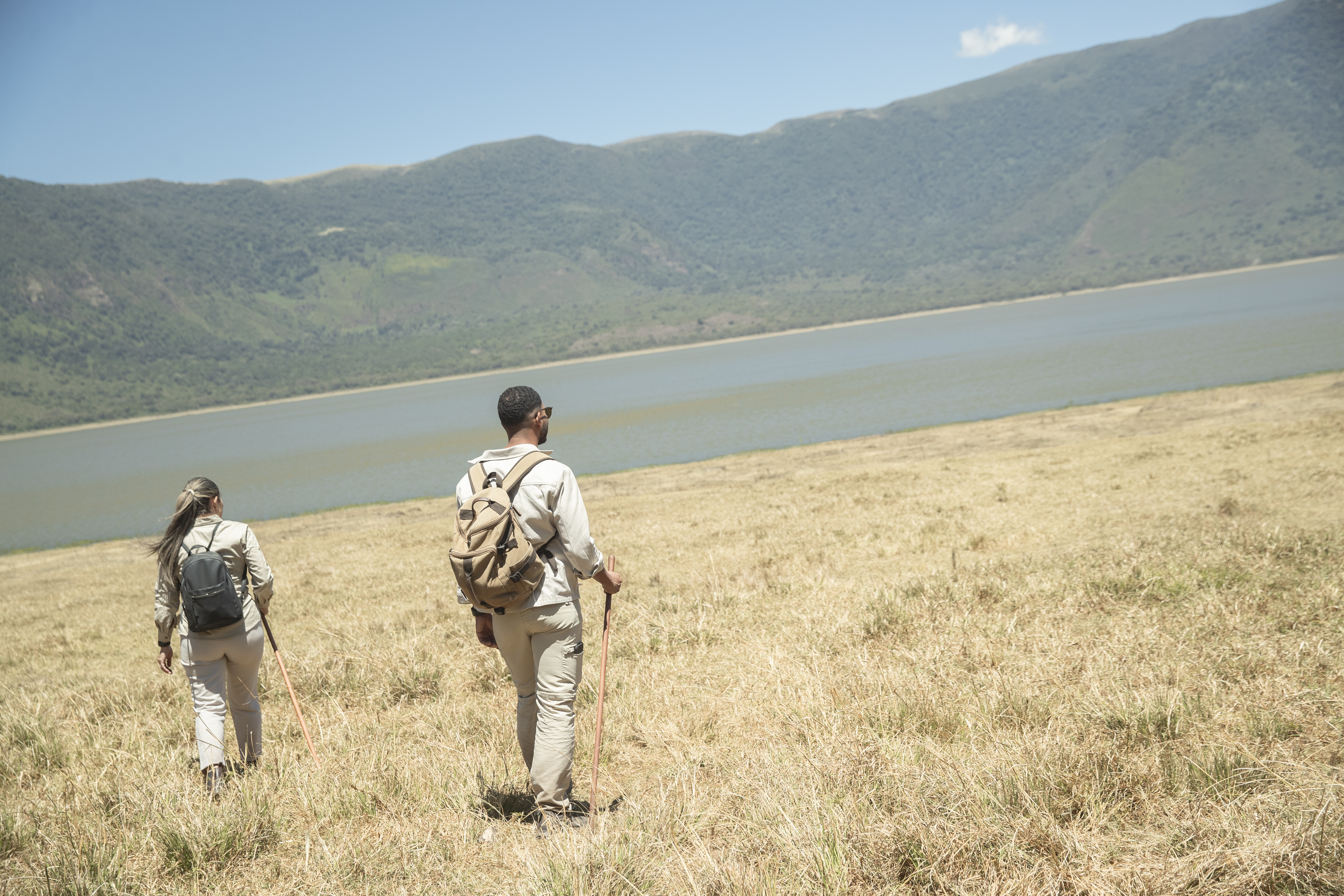 a couple of people hiking in a field