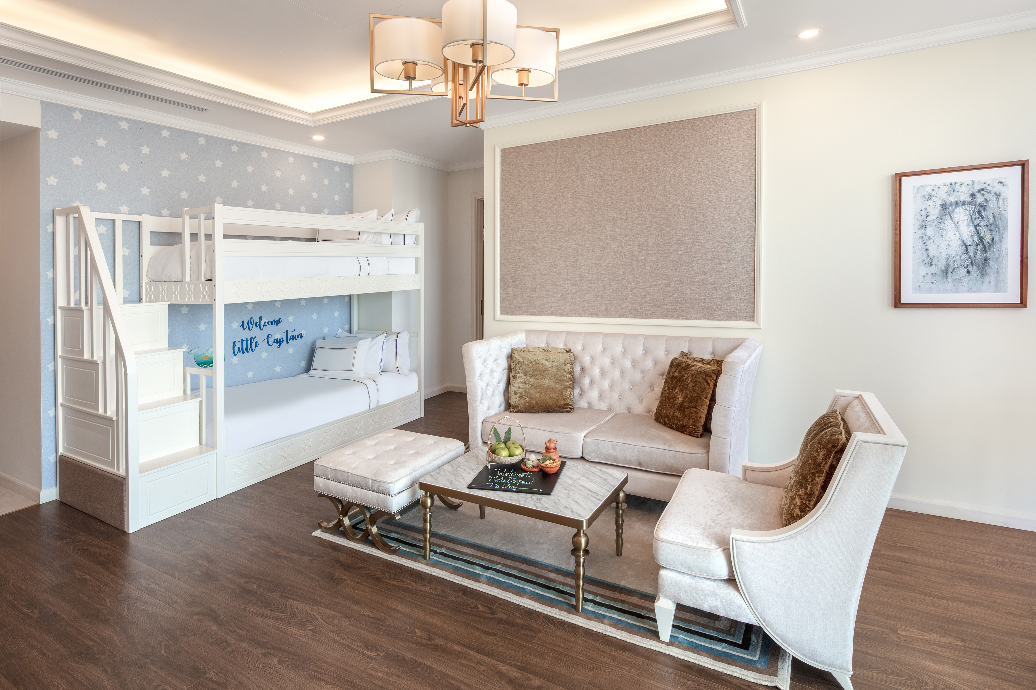 Elegant family suite: white bunk bed, starry wall, cream sofa, coffee table.