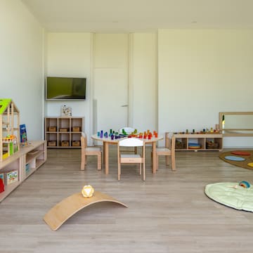 a room with a table and chairs and toys