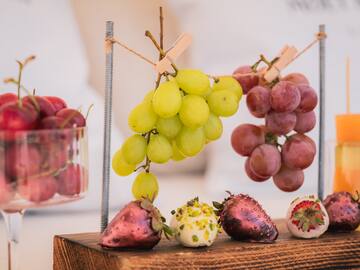 a group of grapes and strawberries on a wood block