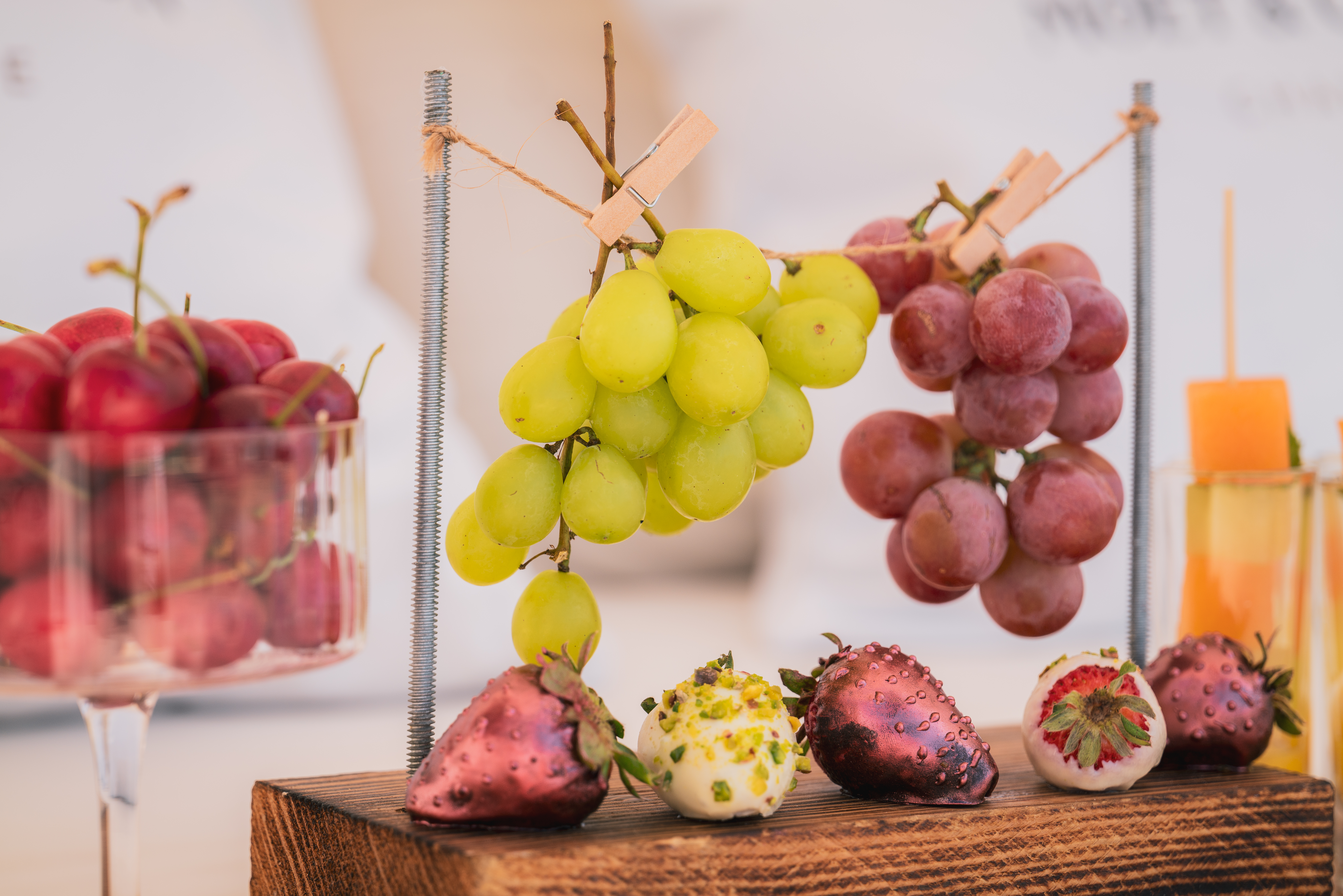 a group of grapes and strawberries on a wood block