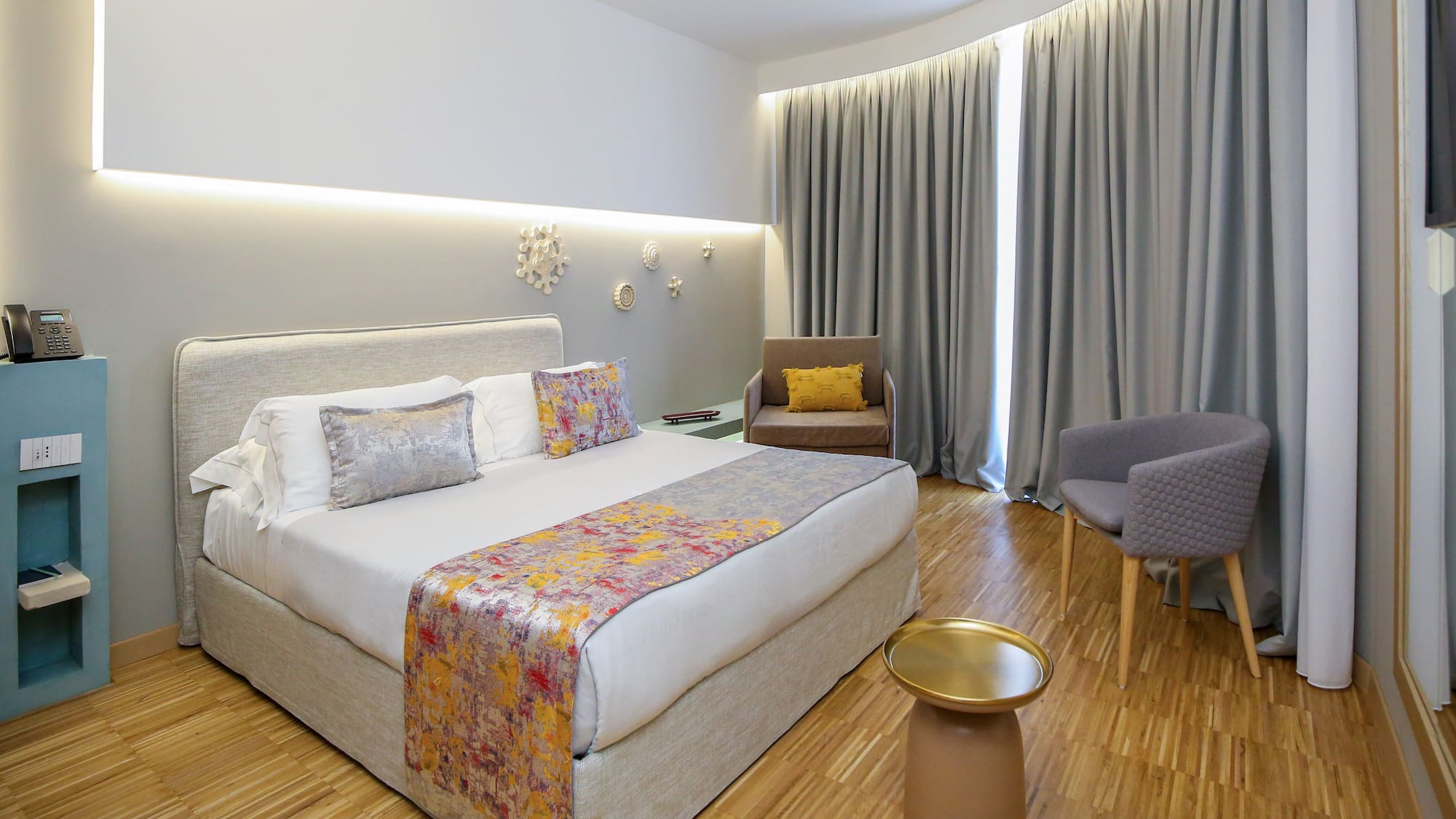 a room with a bed and chairs