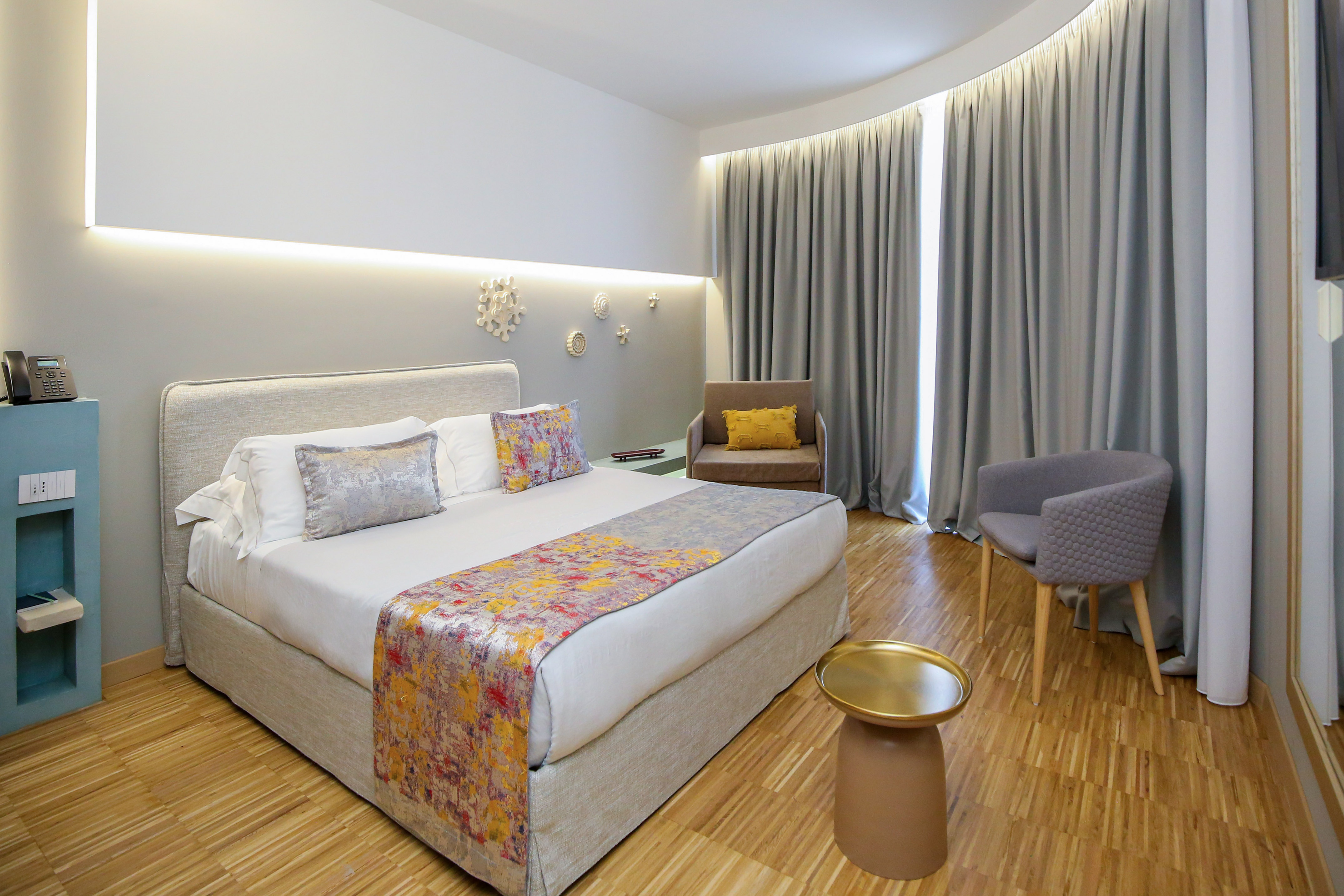 a room with a bed and chairs