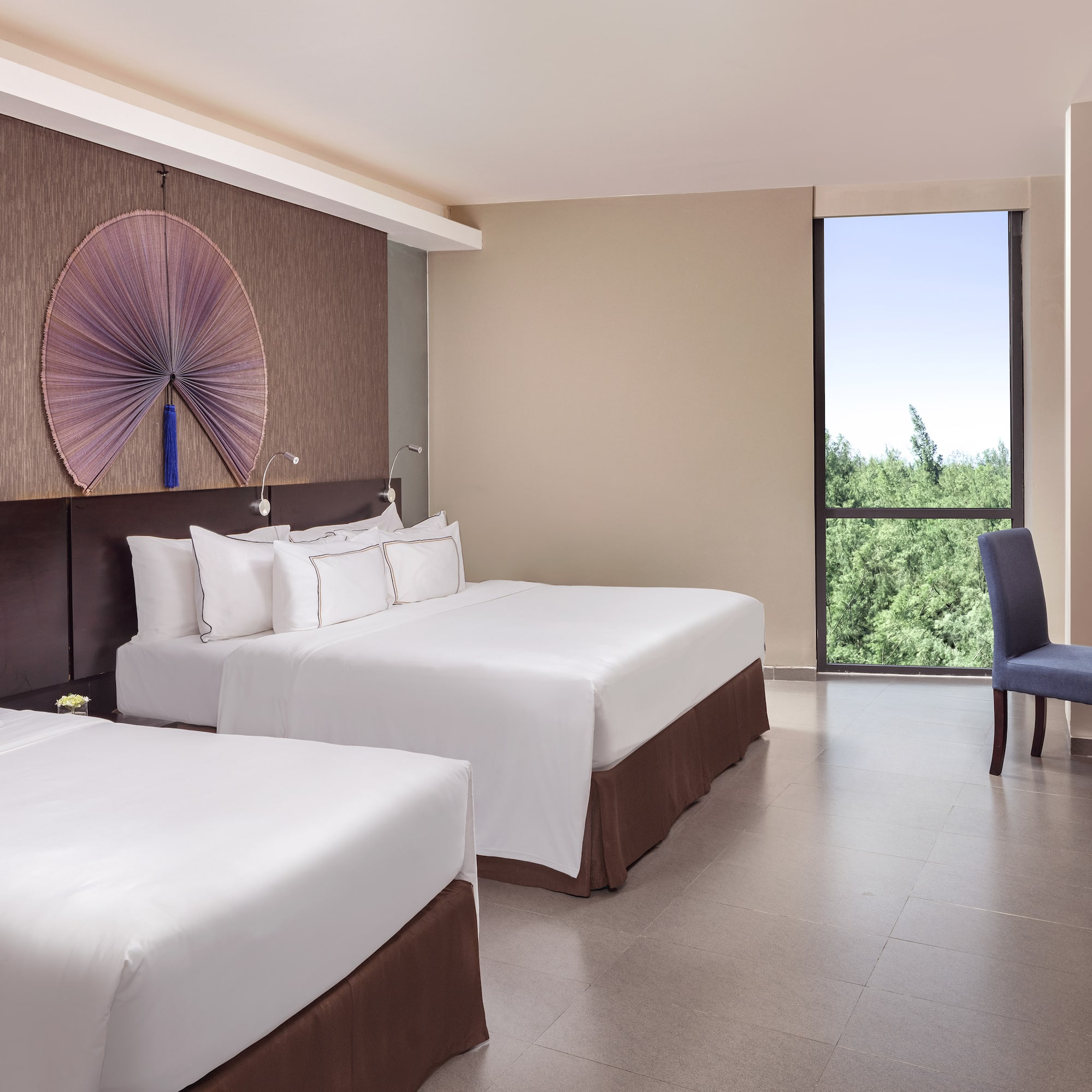 a room with two beds and a blue chair