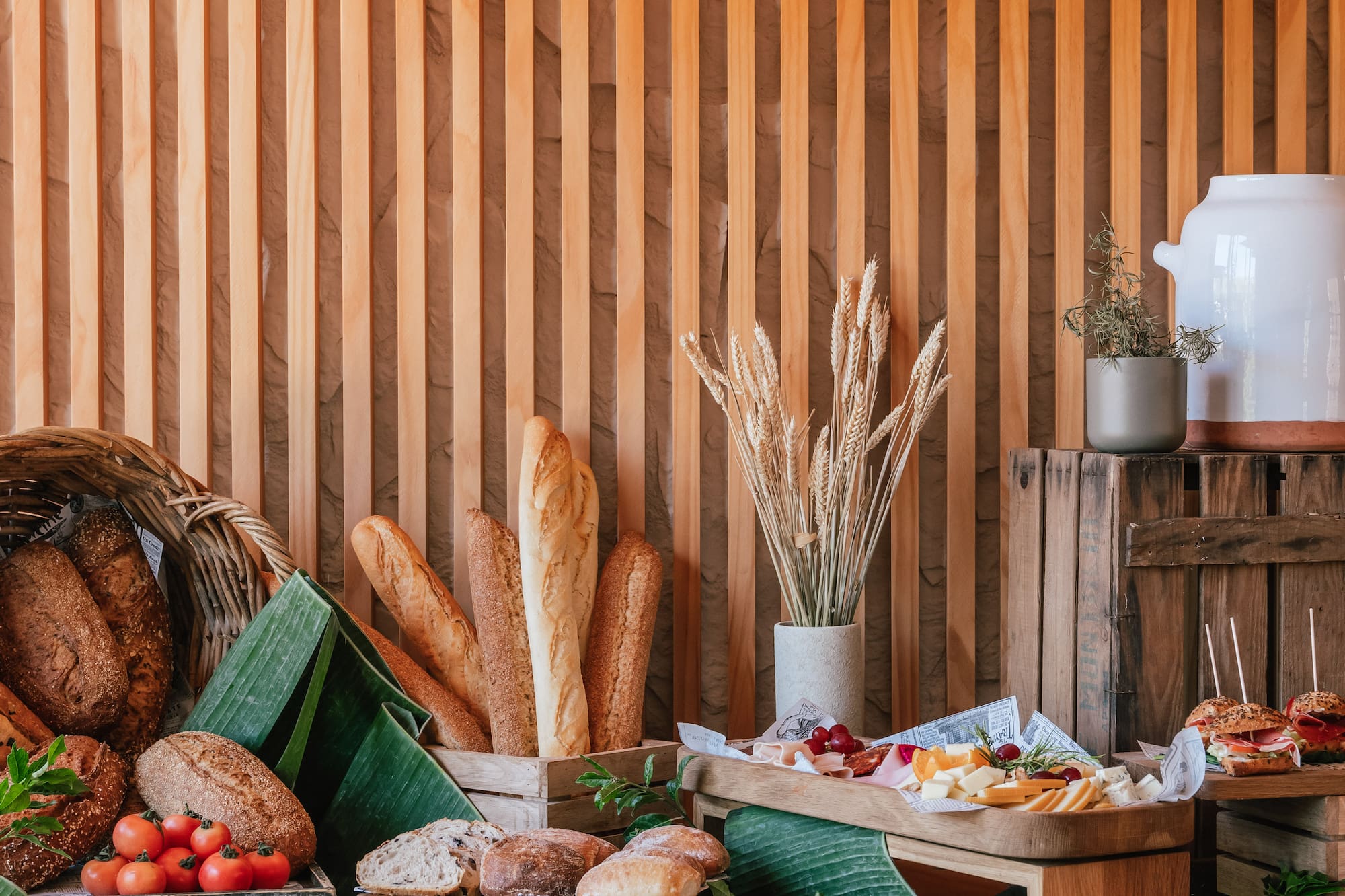 Hotel breakfast buffet with fresh bread, cheeses, cold cuts, and vegetables.