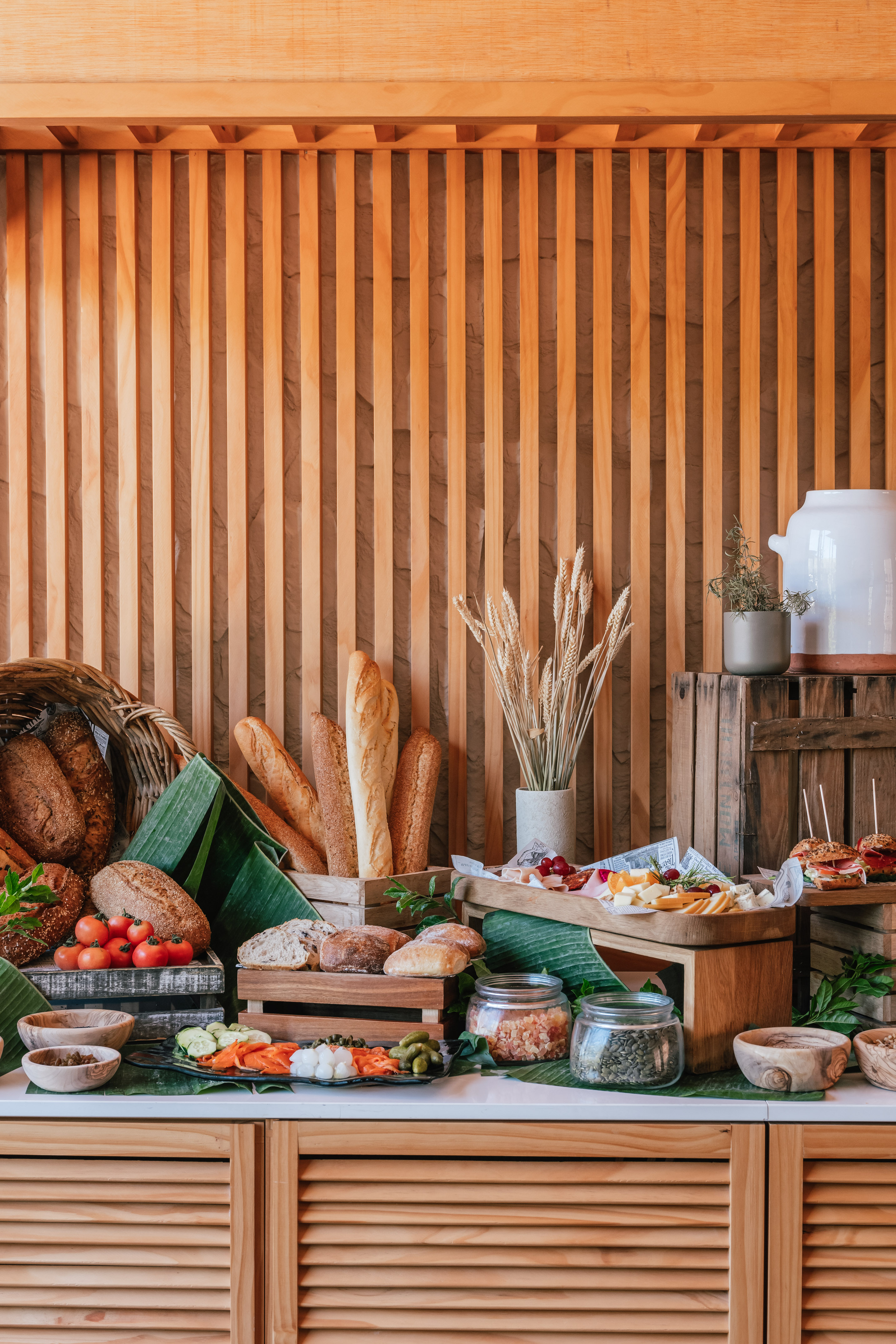 Hotel breakfast buffet with fresh bread, cheeses, cold cuts, and vegetables.