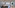 Modern industrial studio with port view, concrete ceiling, and bedroom.