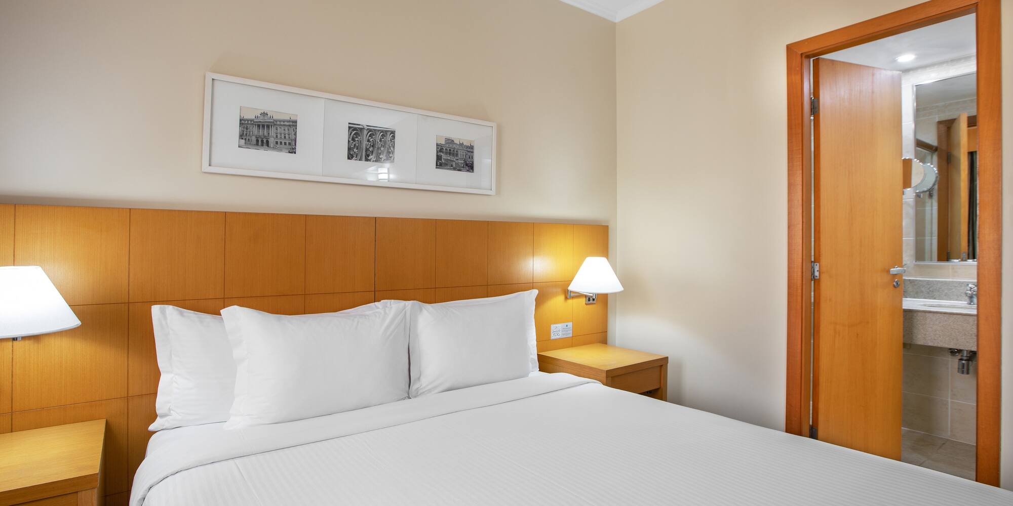 a bed with white sheets and a lamp