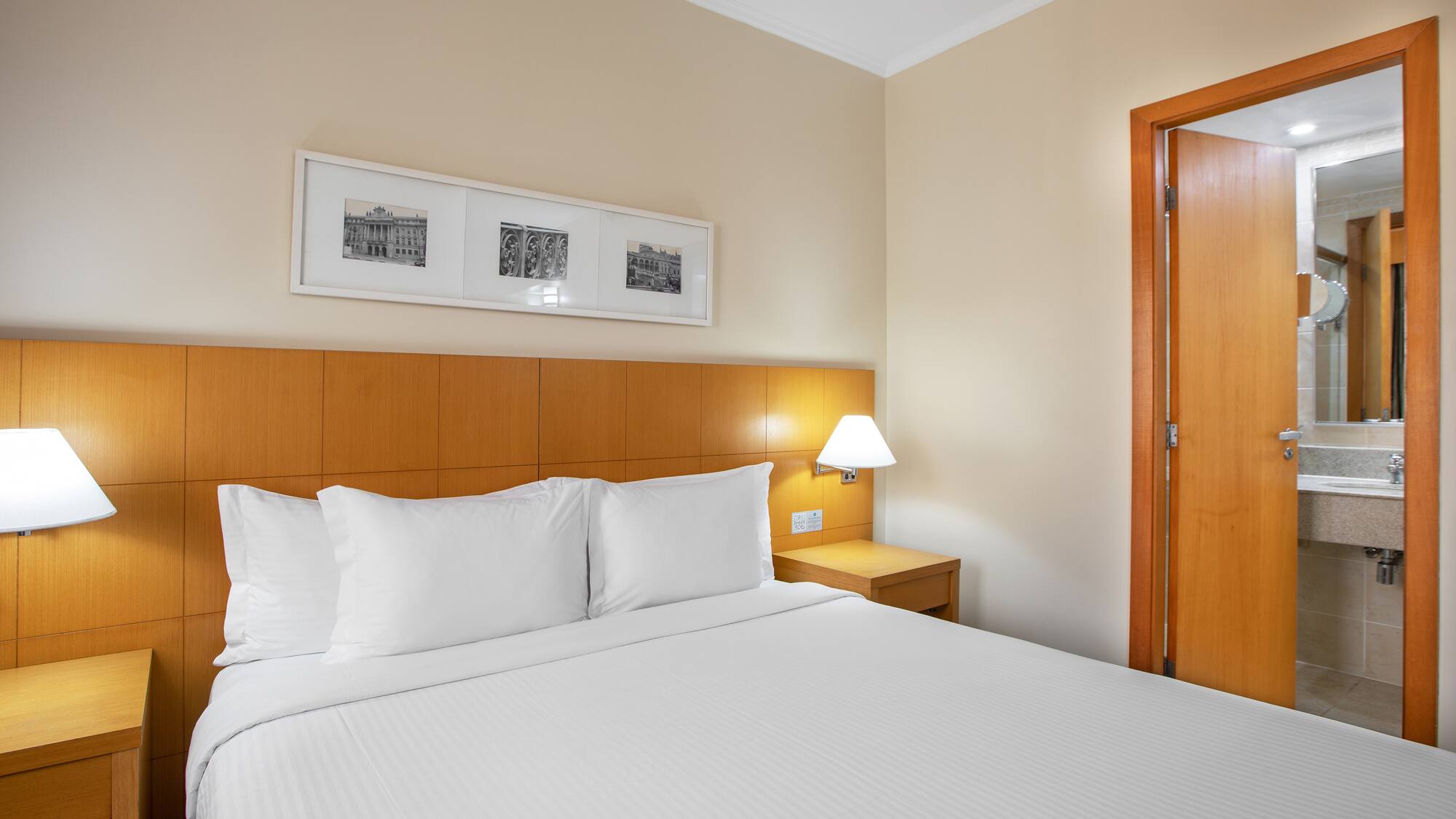 a bed with white sheets and a lamp