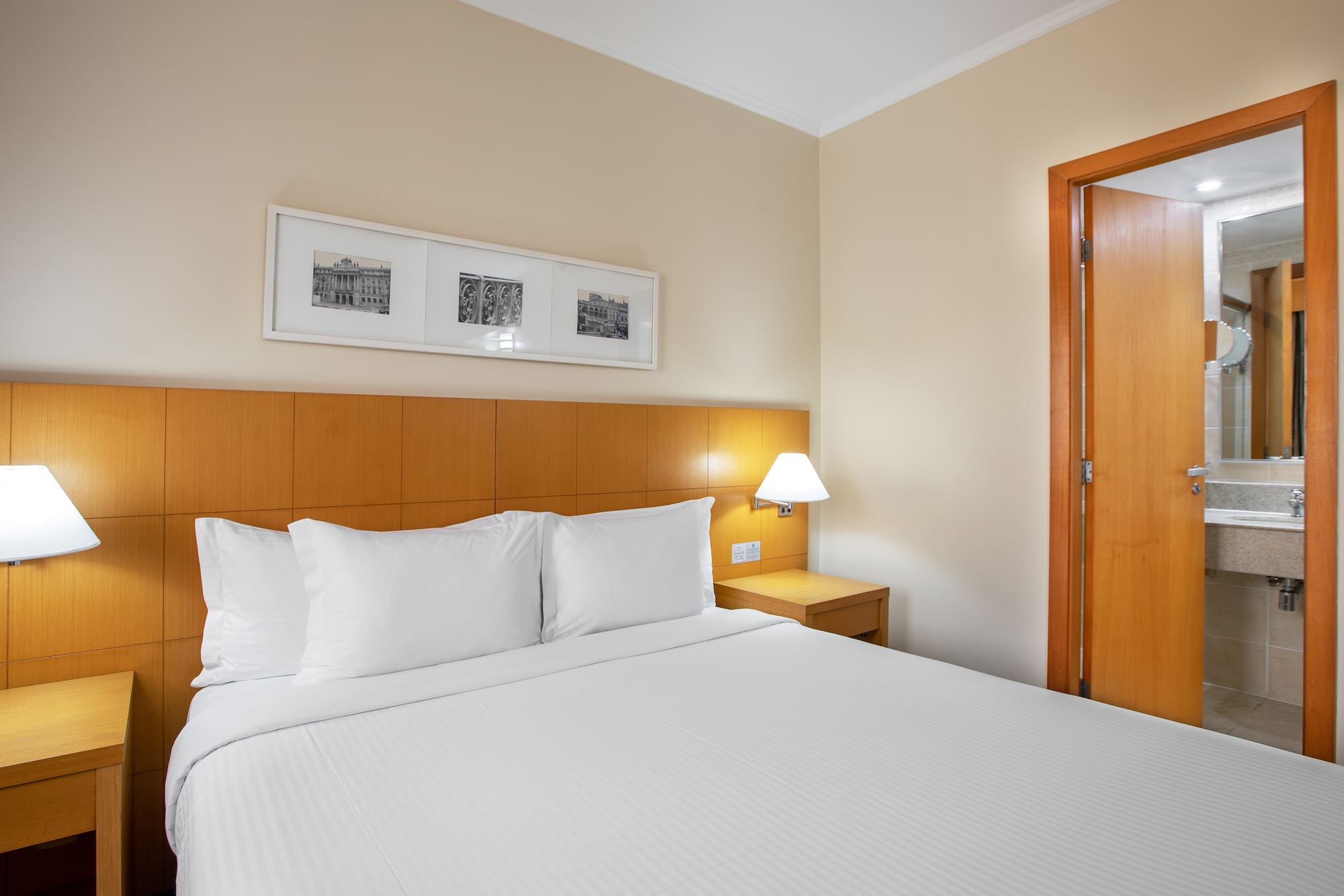 a bed with white sheets and a lamp