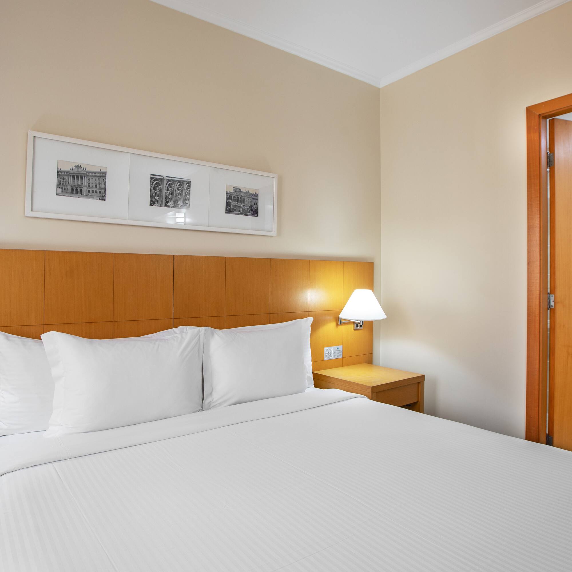 a bed with white sheets and a lamp