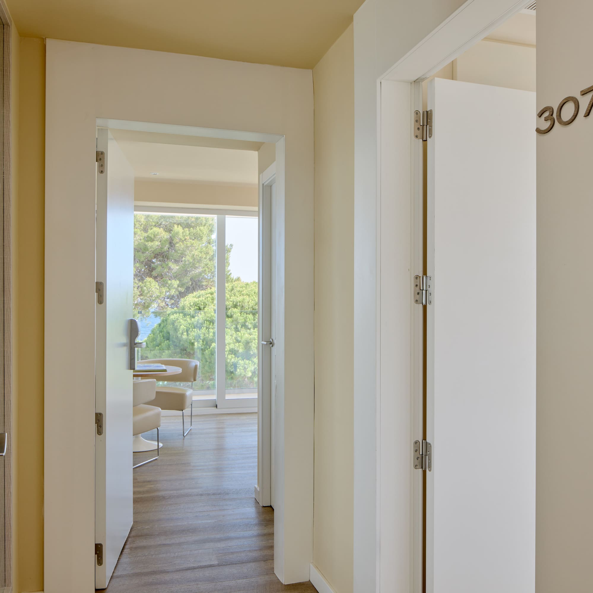 Hotel hallway with room 307, modern keycard entry, and suite with ocean view.