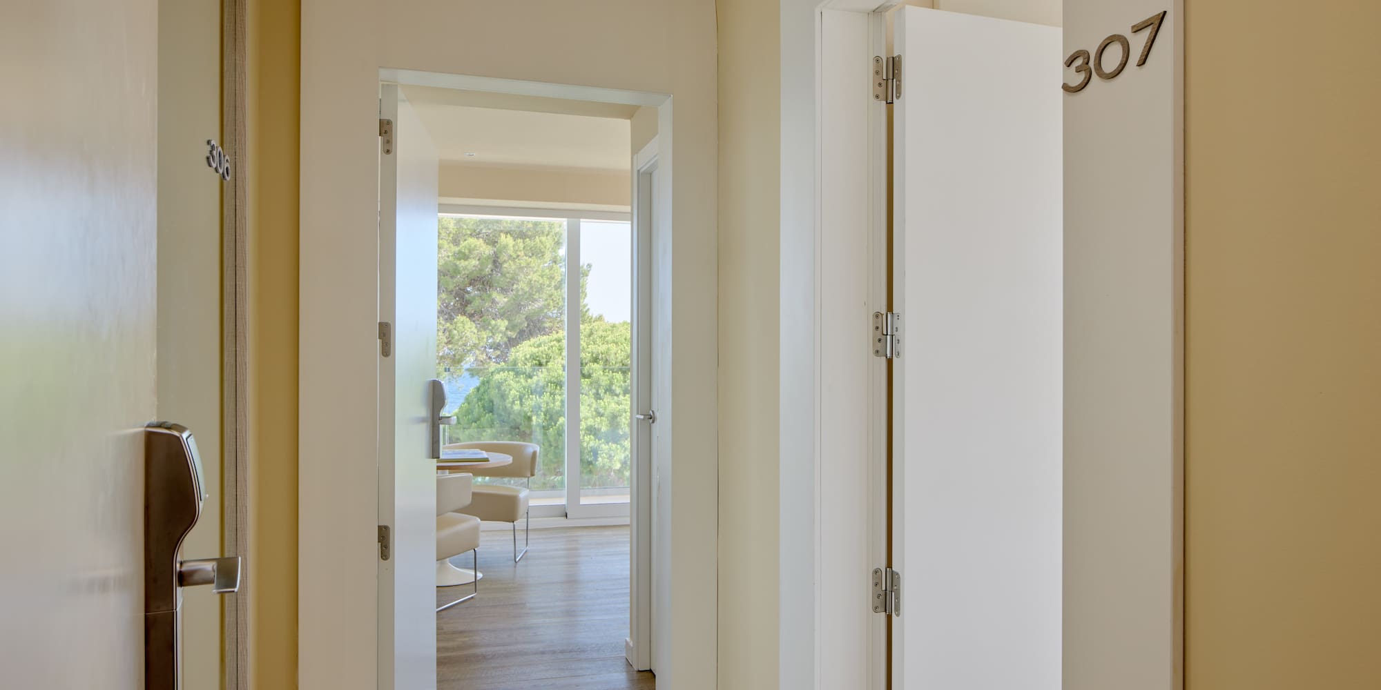 Hotel hallway with room 307, modern keycard entry, and suite with ocean view.