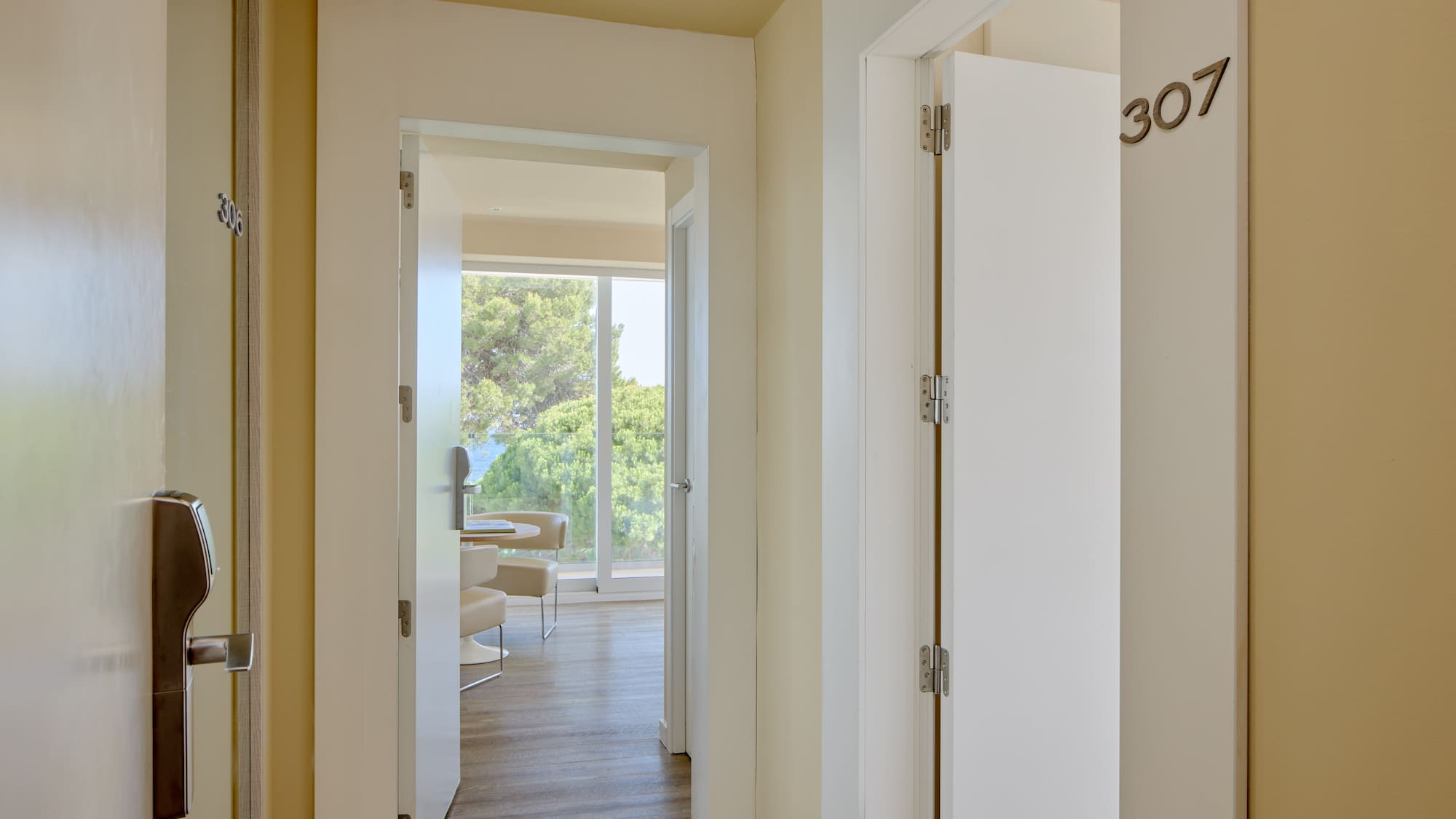 Hotel hallway with room 307, modern keycard entry, and suite with ocean view.