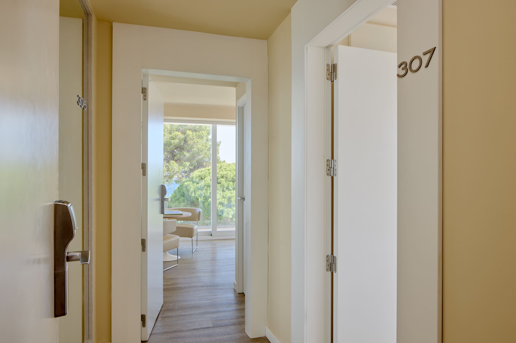 Hotel hallway with room 307, modern keycard entry, and suite with ocean view.